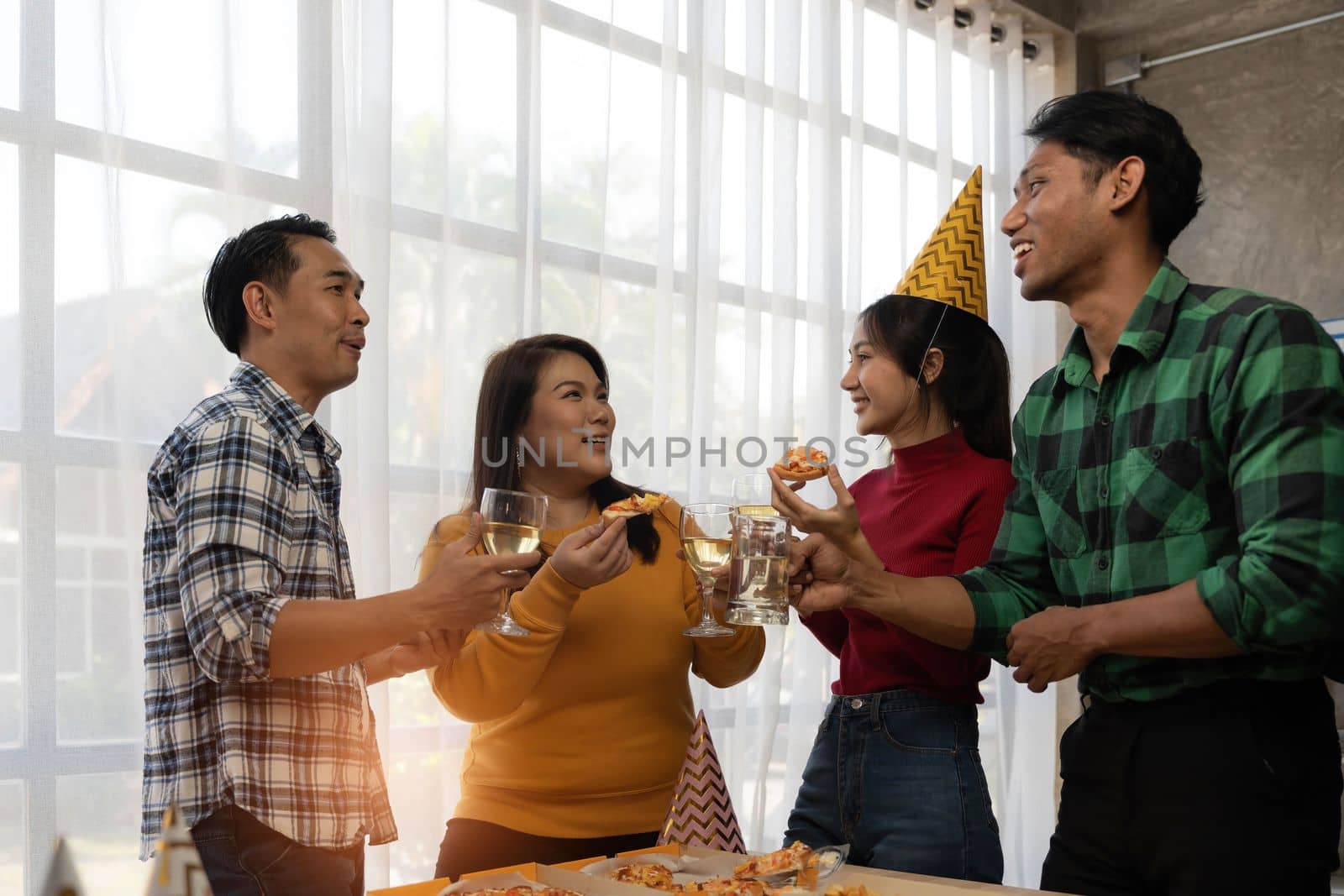 Group of asian friends eating pizza during party at home. Happy asian people having fun together, eating pizza food and beer together with happiness and fun