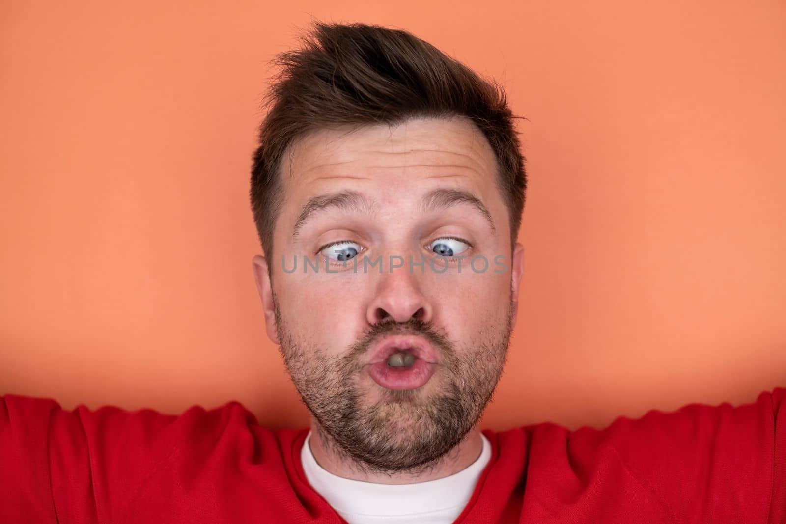 young man expressing surprise on camera isolated over gray background