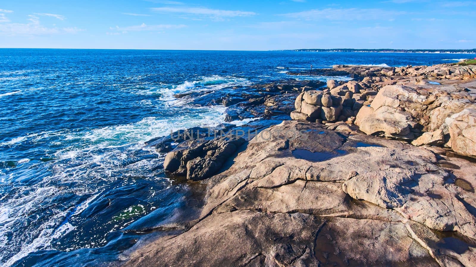 Rocky coasts of Maine with ocean waves crashing into cliffs by njproductions