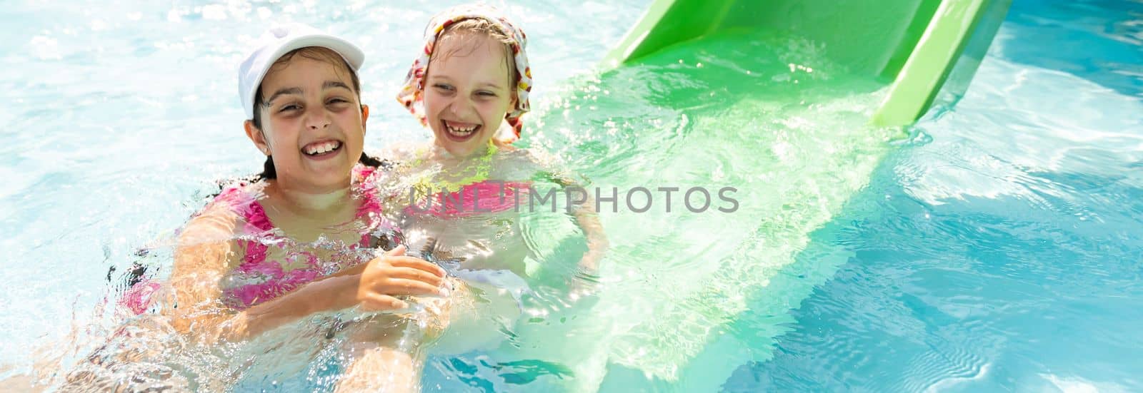 Happy children in the swimming pool. Funny kids playing outdoors. Summer vacation concept. by Andelov13