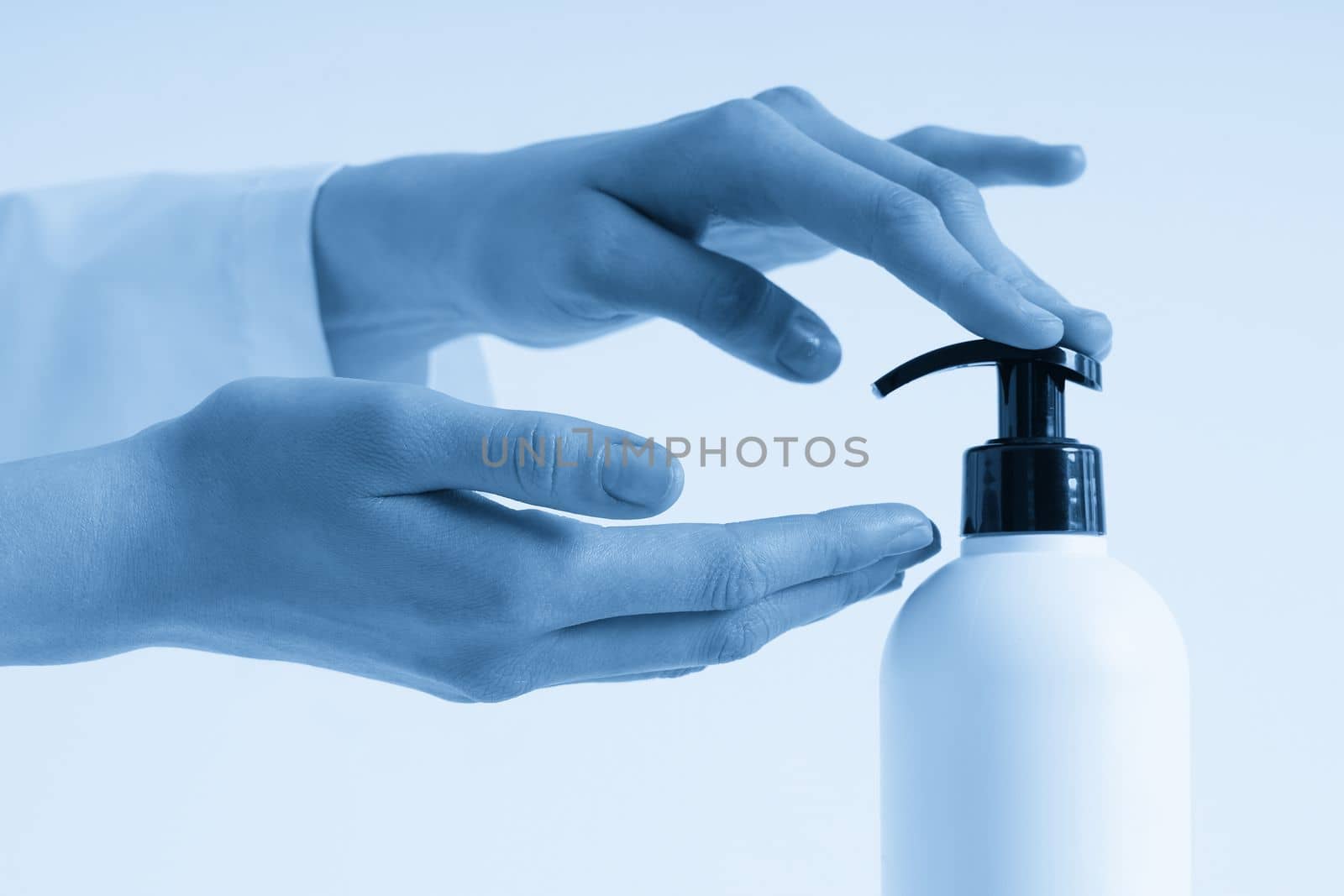 Woman hands pushing pump plastic soap bottle with copy space, using wash hand sanitizer gel pump dispenser. killing germs, bacteria and virus by Mariakray