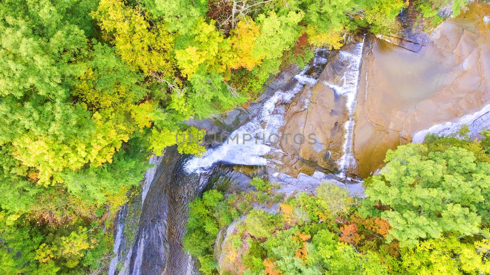 Image of Looking down over waterfall going into deep gorge surrounded by green forest