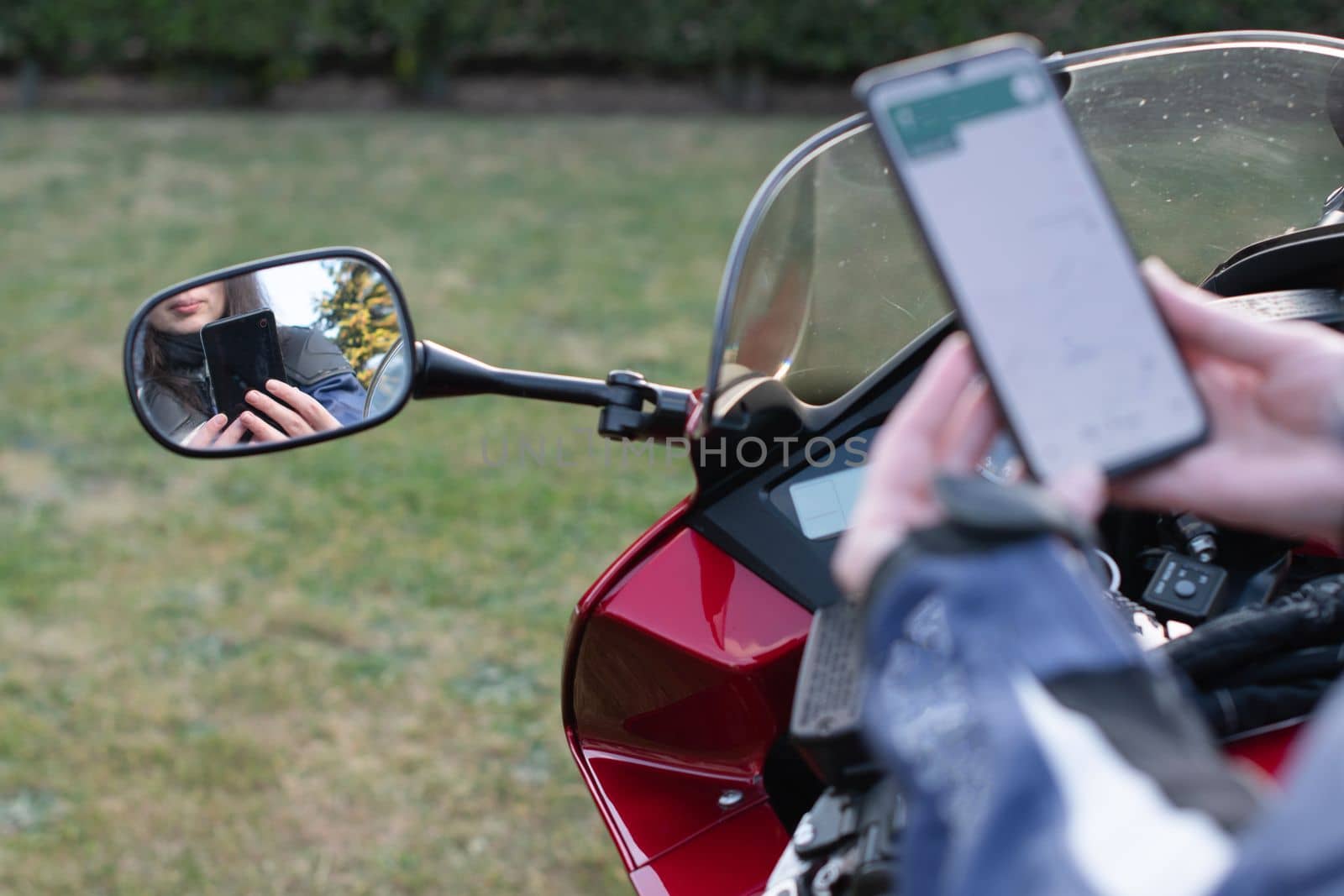 biker girl on a motorcycle enjoys a navigator in a mobile phone by KaterinaDalemans