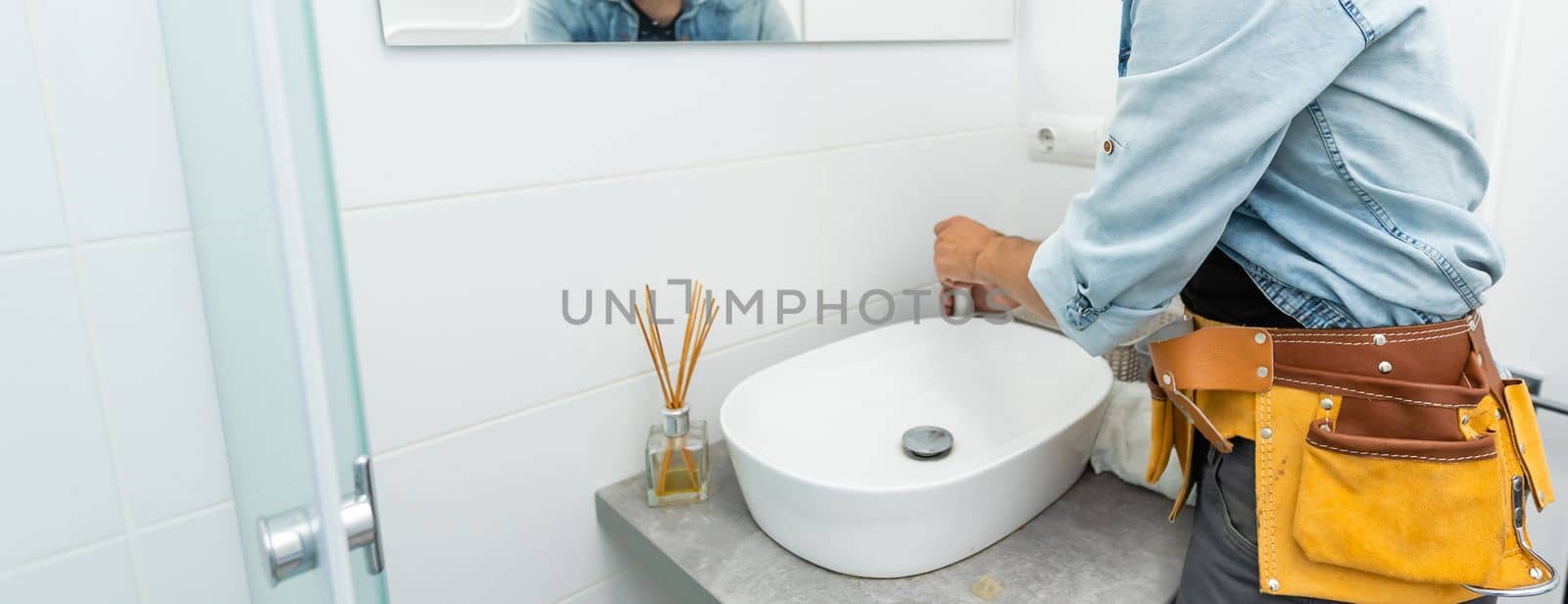 plumber installs a new faucet for a sink.