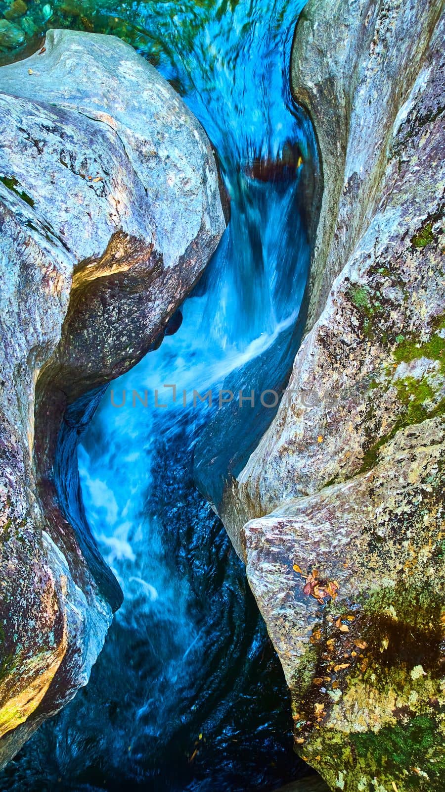 Looking down raging rapids river funneling between two walls of rock in detail by njproductions