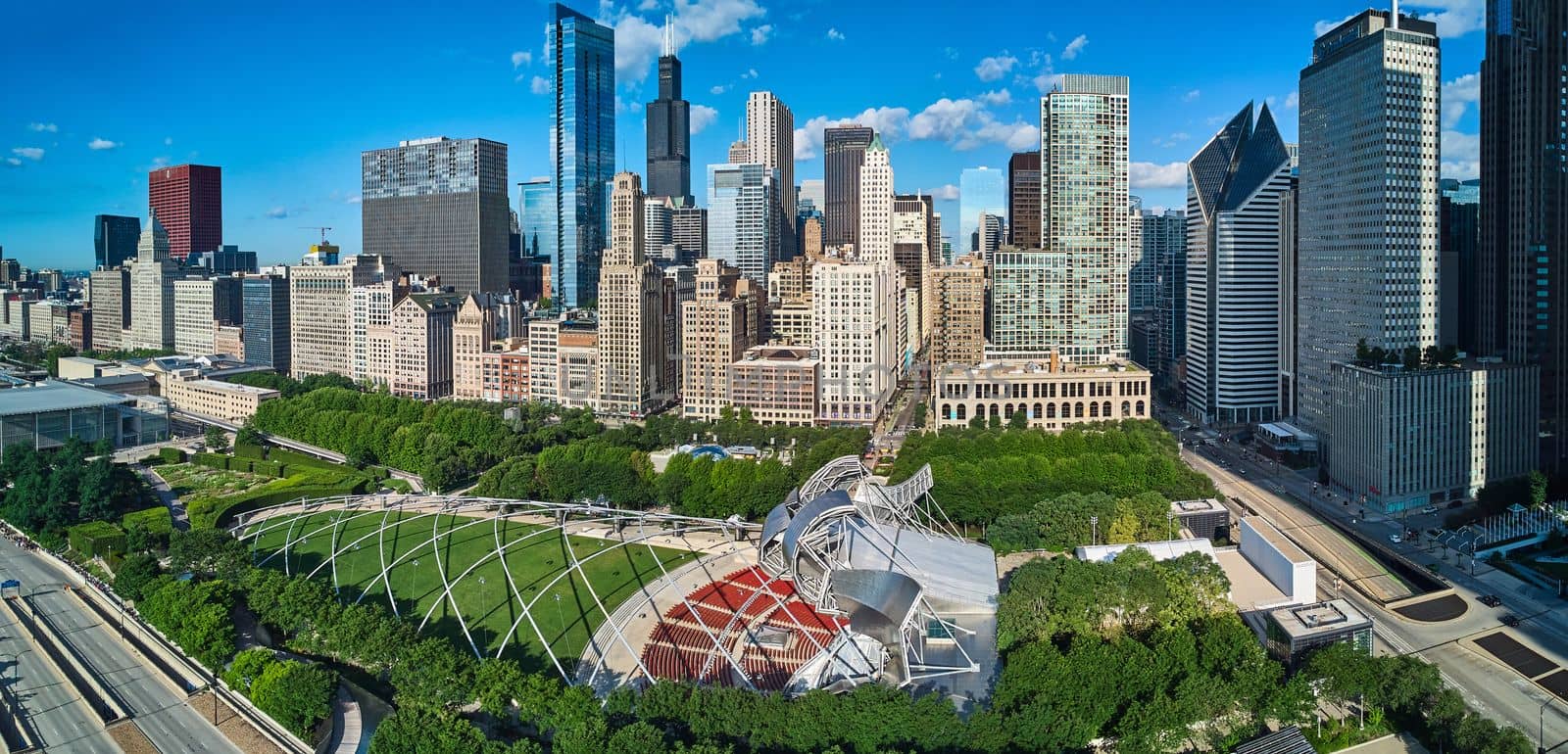 Wide view over Millennium Park with pavilion and line of skyscrapers by njproductions