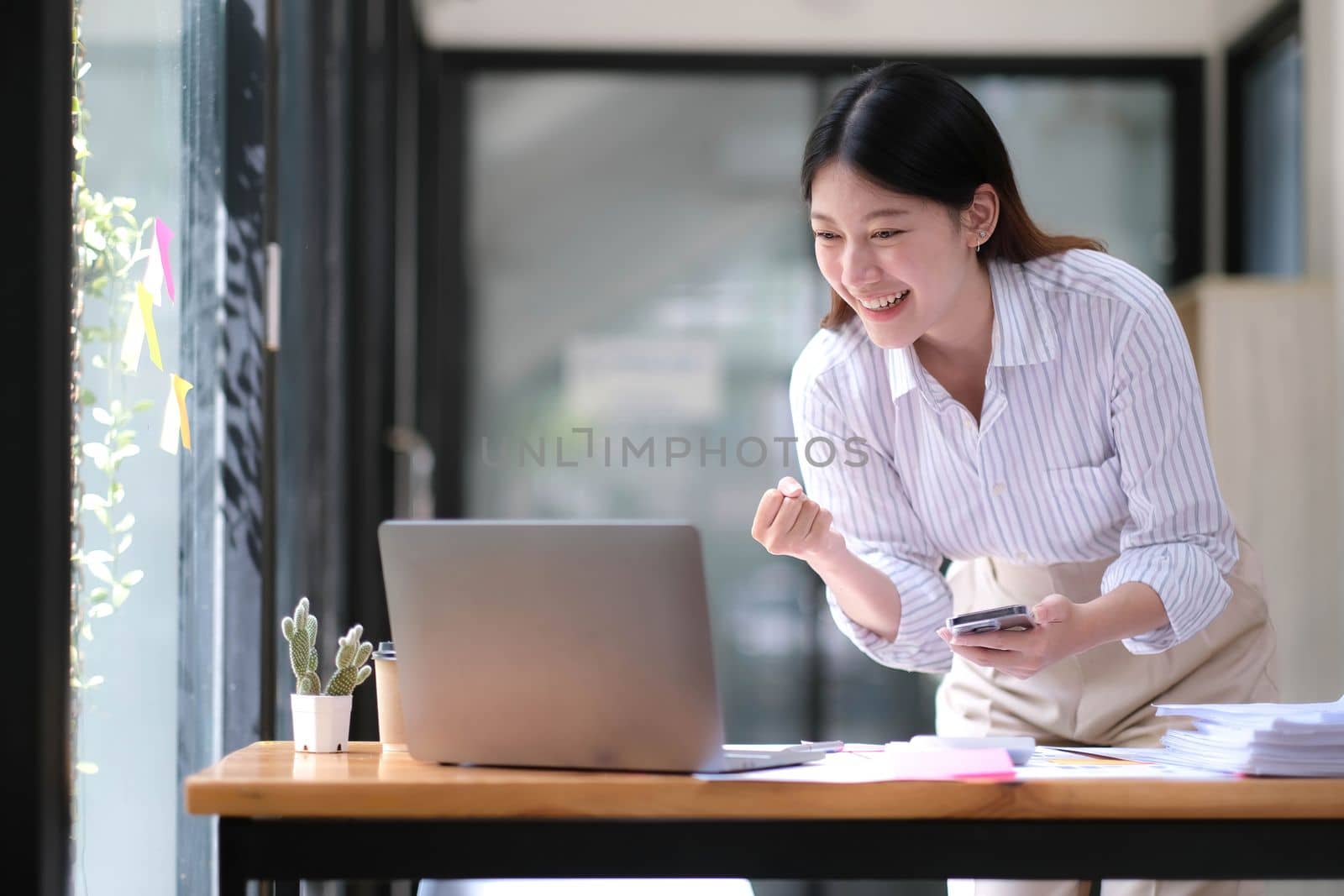 Asian business are excited about celebrating business success with inspiration from their excellent financial results that are happy working in a modern office