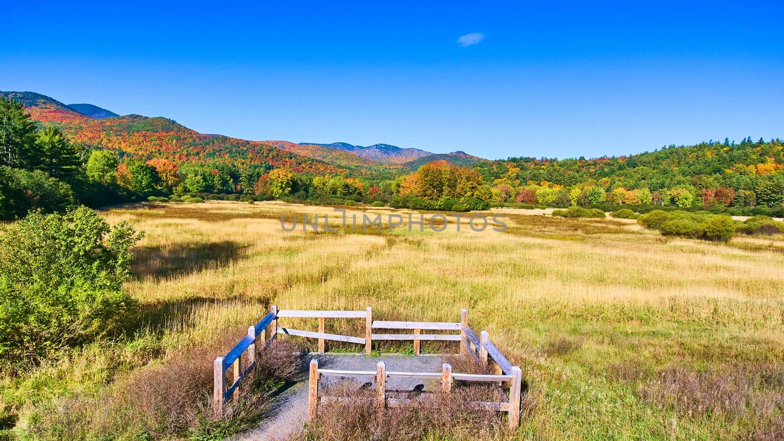 Image of Viewing spot for tourists overlooks beautiful field and colorful fall mountains