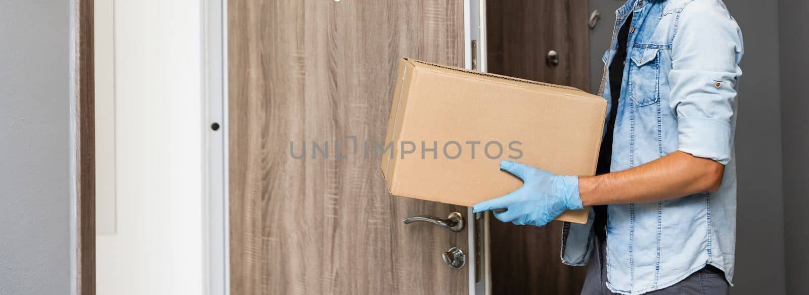 Home delivery shopping box man wearing gloves and protective mask delivering packages at door.