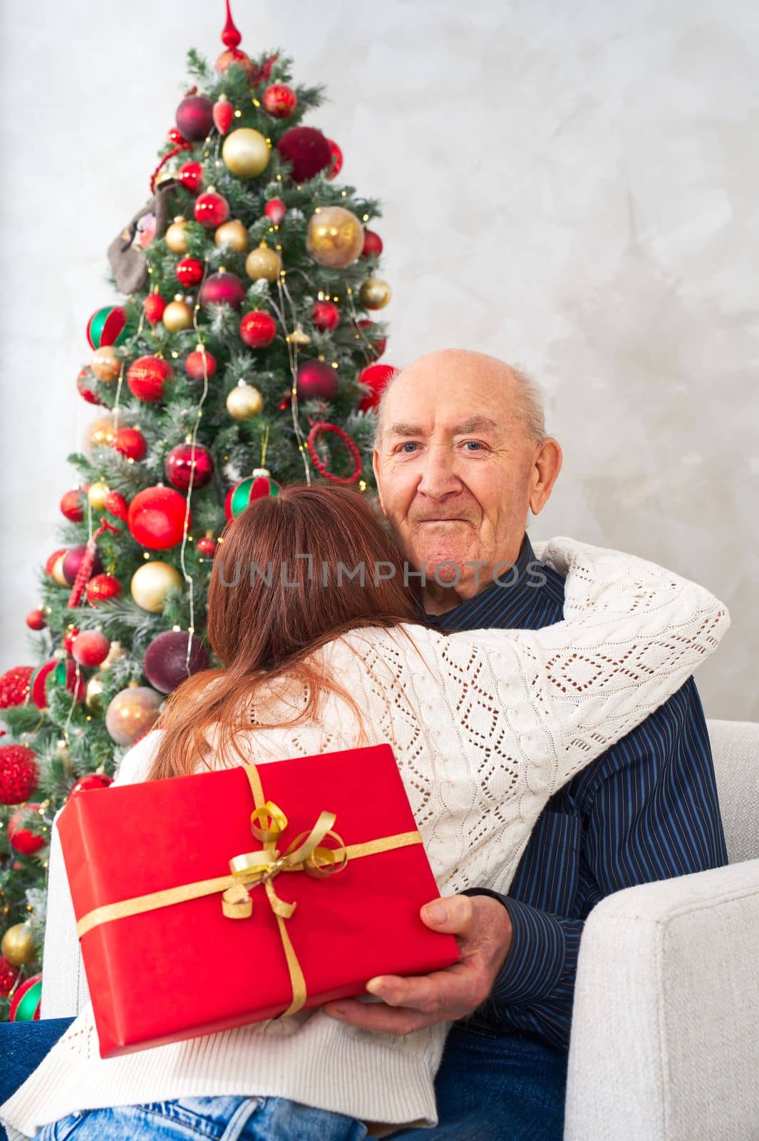 great grandfather and great granddaughter. grandfather getting christmas gift from granddaughter. happy elderly man getting a beautiful present. christmas, xmas, holidays, people and family concept