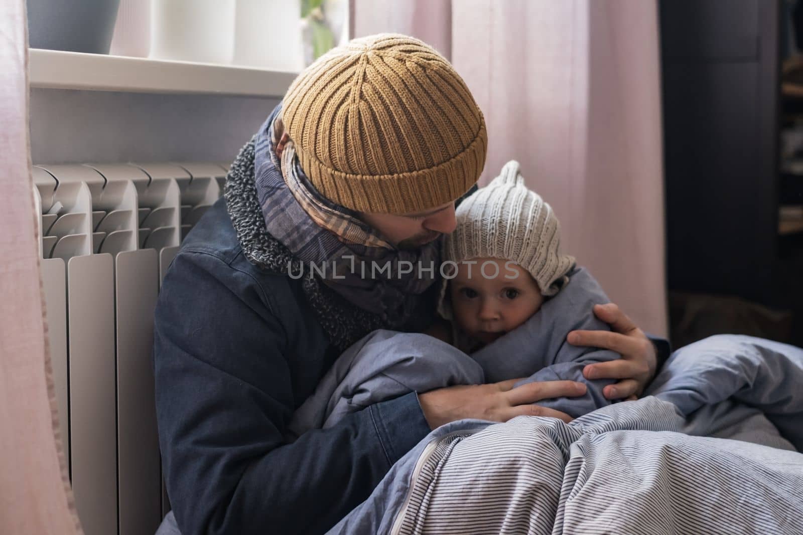 Man wearing warm clothing feeling cold checking central heating battery. Energy crisis in Europe