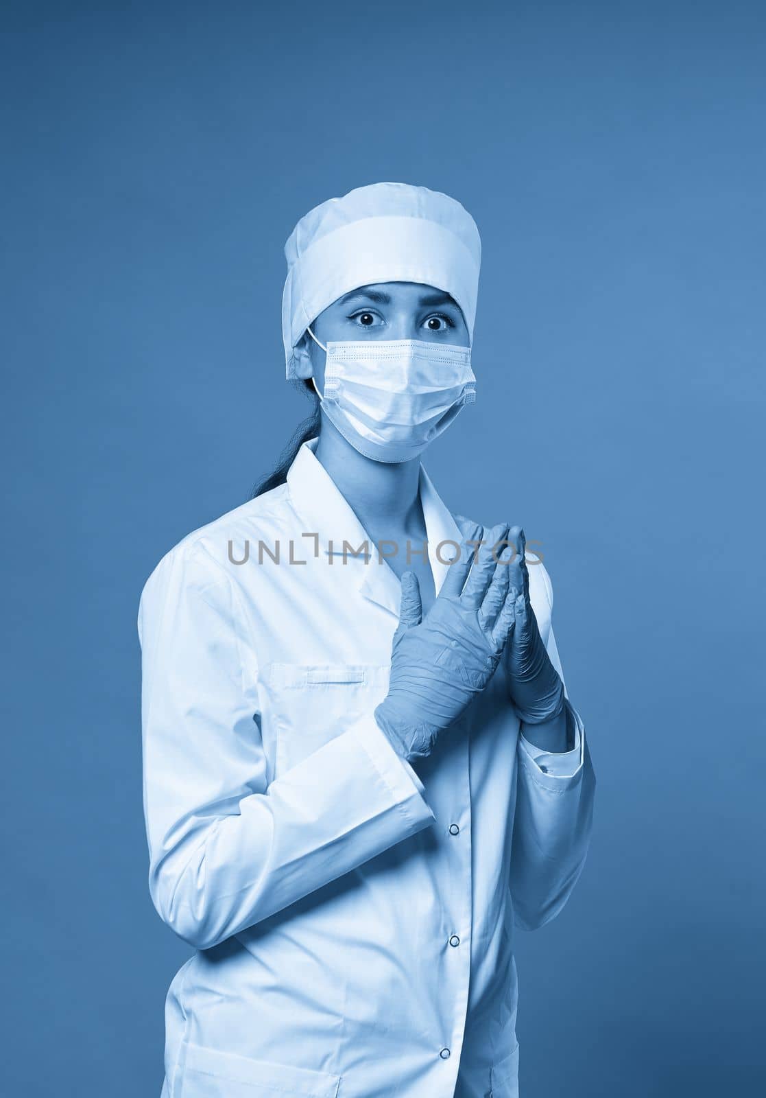 Young doctor with stethoscope against light background,