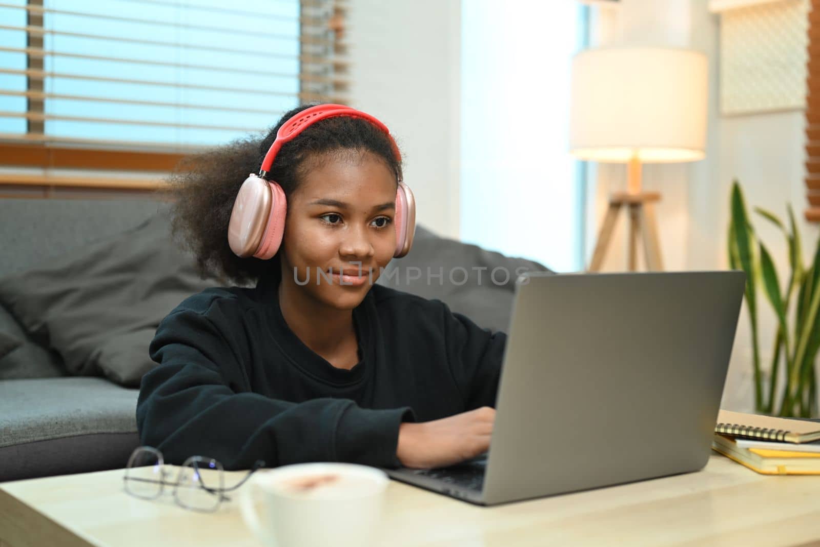 Concentrated teenage woman watching learning online in virtual classroom on laptop computer.