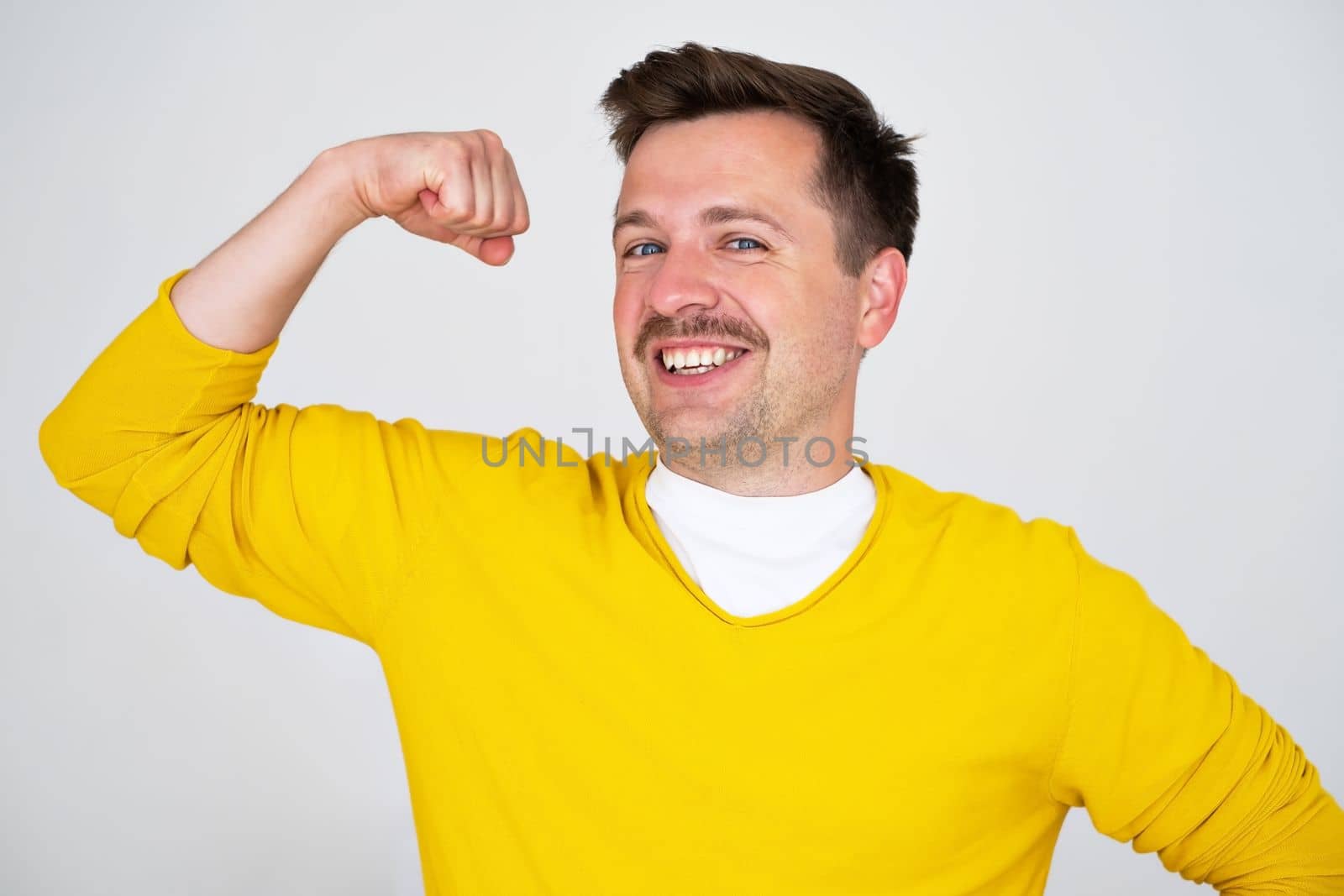 Young caucasian man showing arms muscles smiling proud. Fitness concept. 