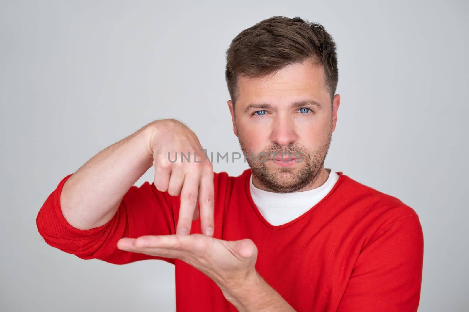 Caucasian man showing two fingers on his palm, gesture meaning go by foot, afoot. No petrol in car.
