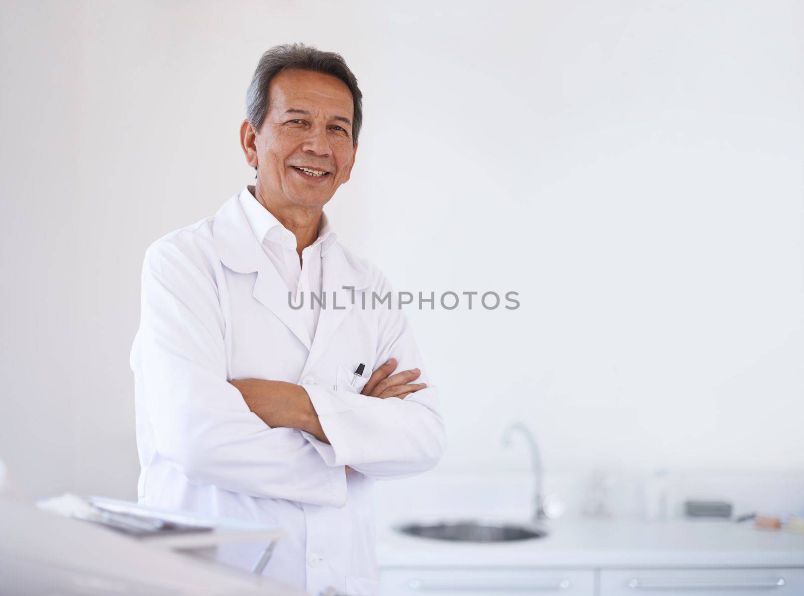 Hes the best surgeon around. Portrait of a mature male surgeon standing in the hospital