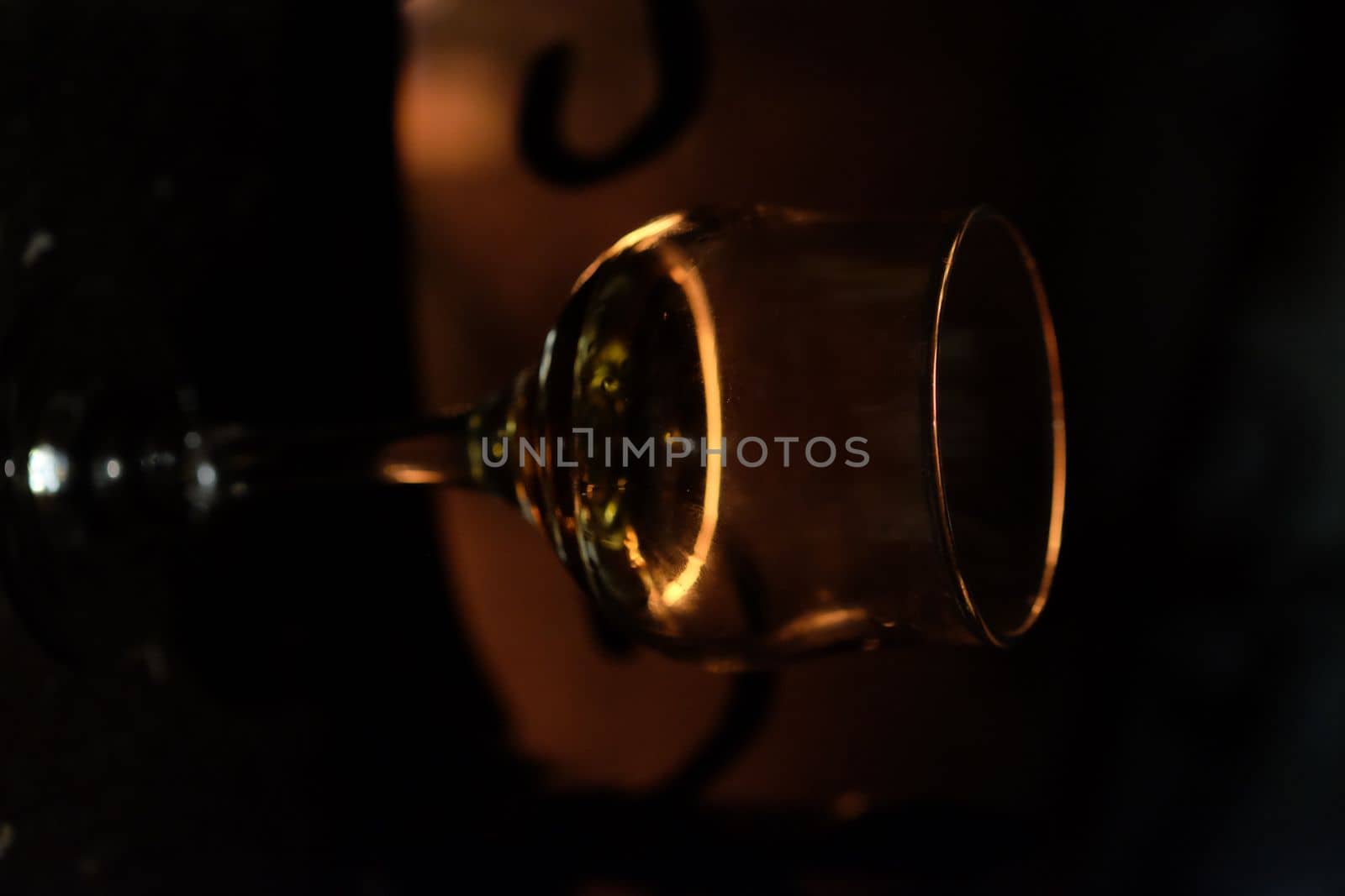 Glass of wine against the backdrop of a bonfire in the fireplace by Dustick