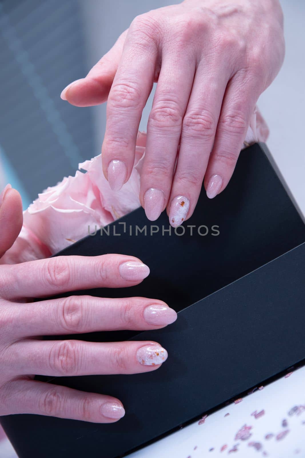 pink wedding manicure for the bride, a girls hand on the black heart shape box. High quality photo