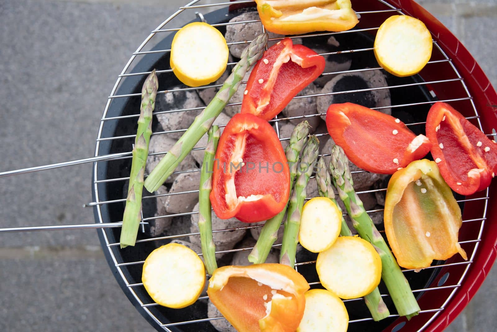 barbecue of colorful raw vegetables on a grill on blue shabby boards, vegetarian food, delicious vegan food, summer picnics. High quality photo