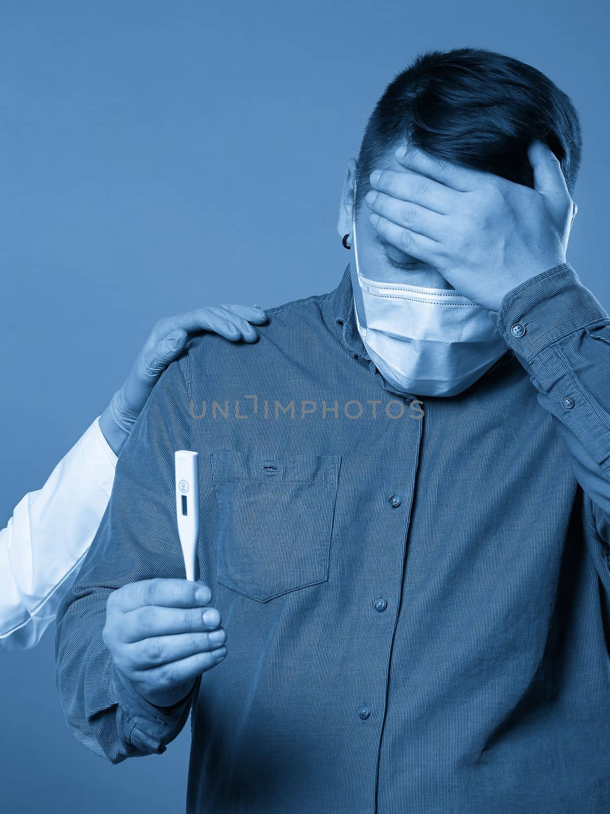 Young man in casual cloth wearing medical protective mask excited, stressed and frightened after read very high temperature result from digital thermometer
