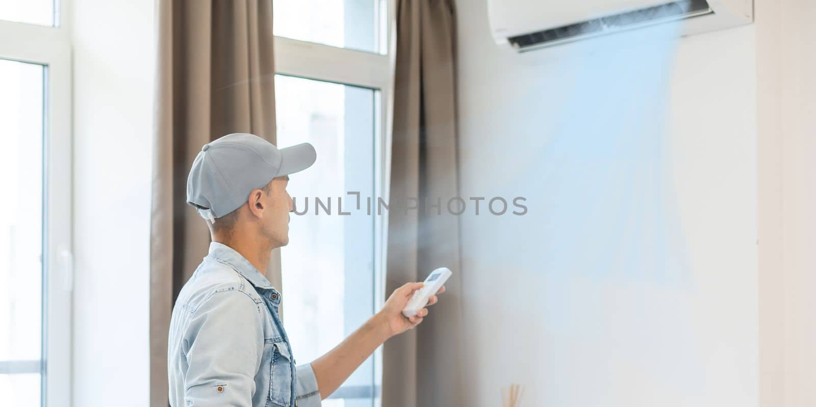 Professional mature master installs the air conditioning in the room