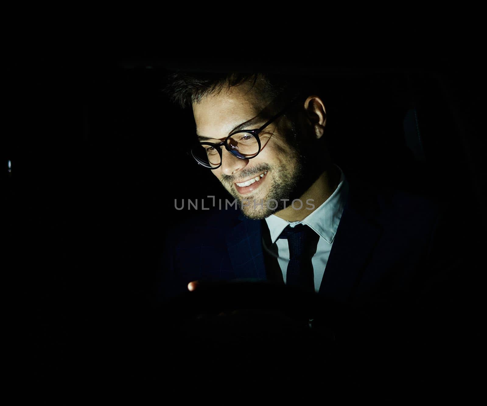 Portrait of a young businessman with tablet or laptop working late at night in office