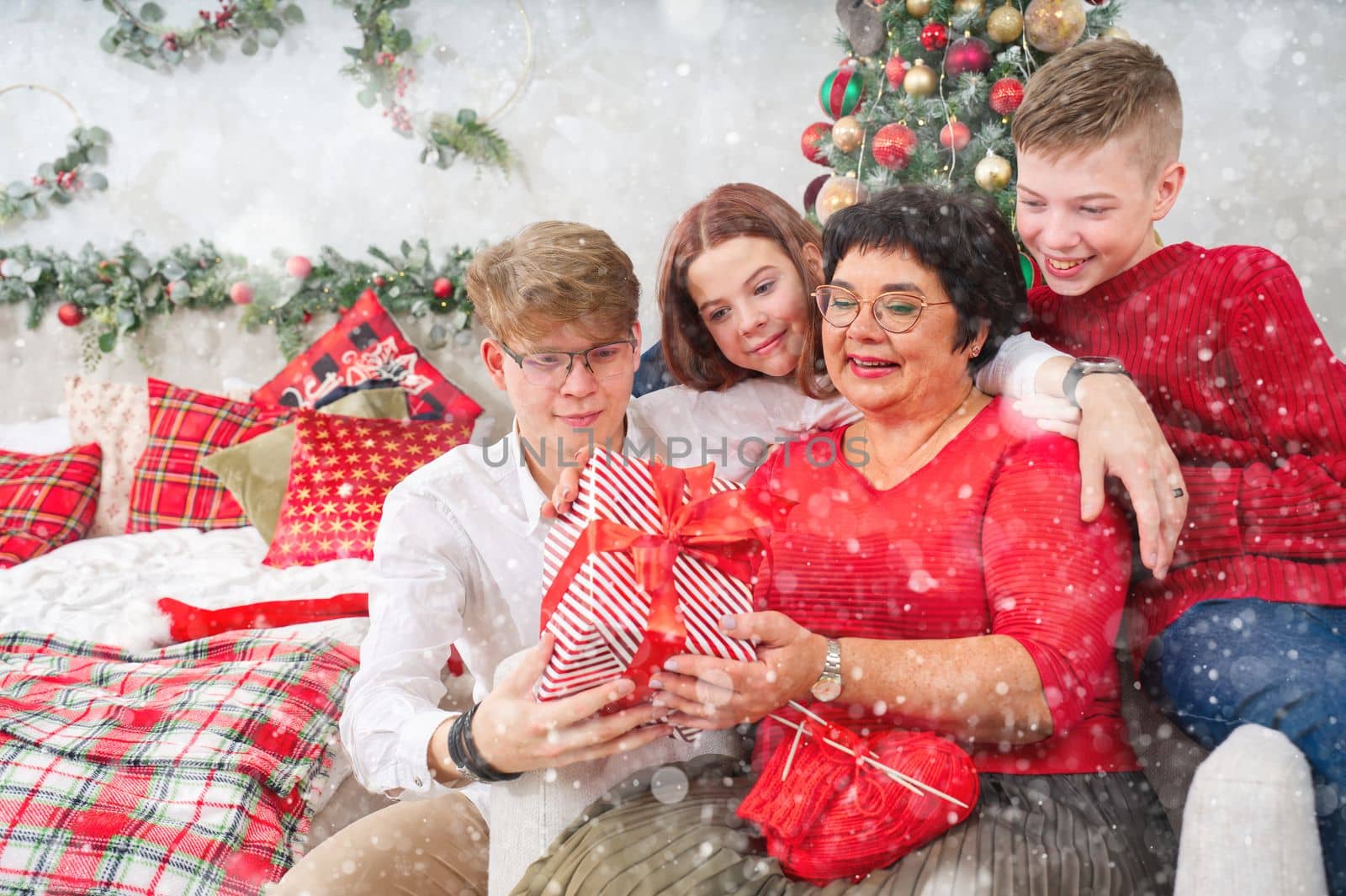 Mother with three children unpacks a christmas gift. christmas wonder by PhotoTime