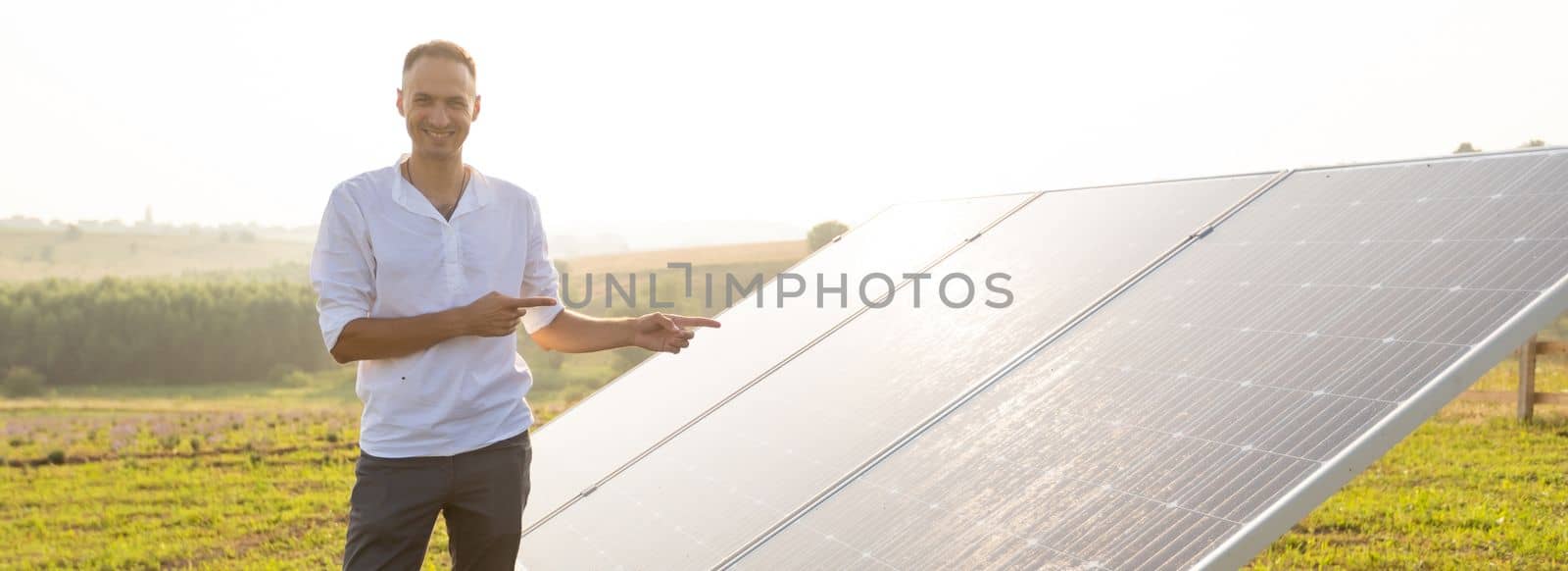 Solar panel on blue sky background. Green grass and cloudy sky. Alternative energy concept.
