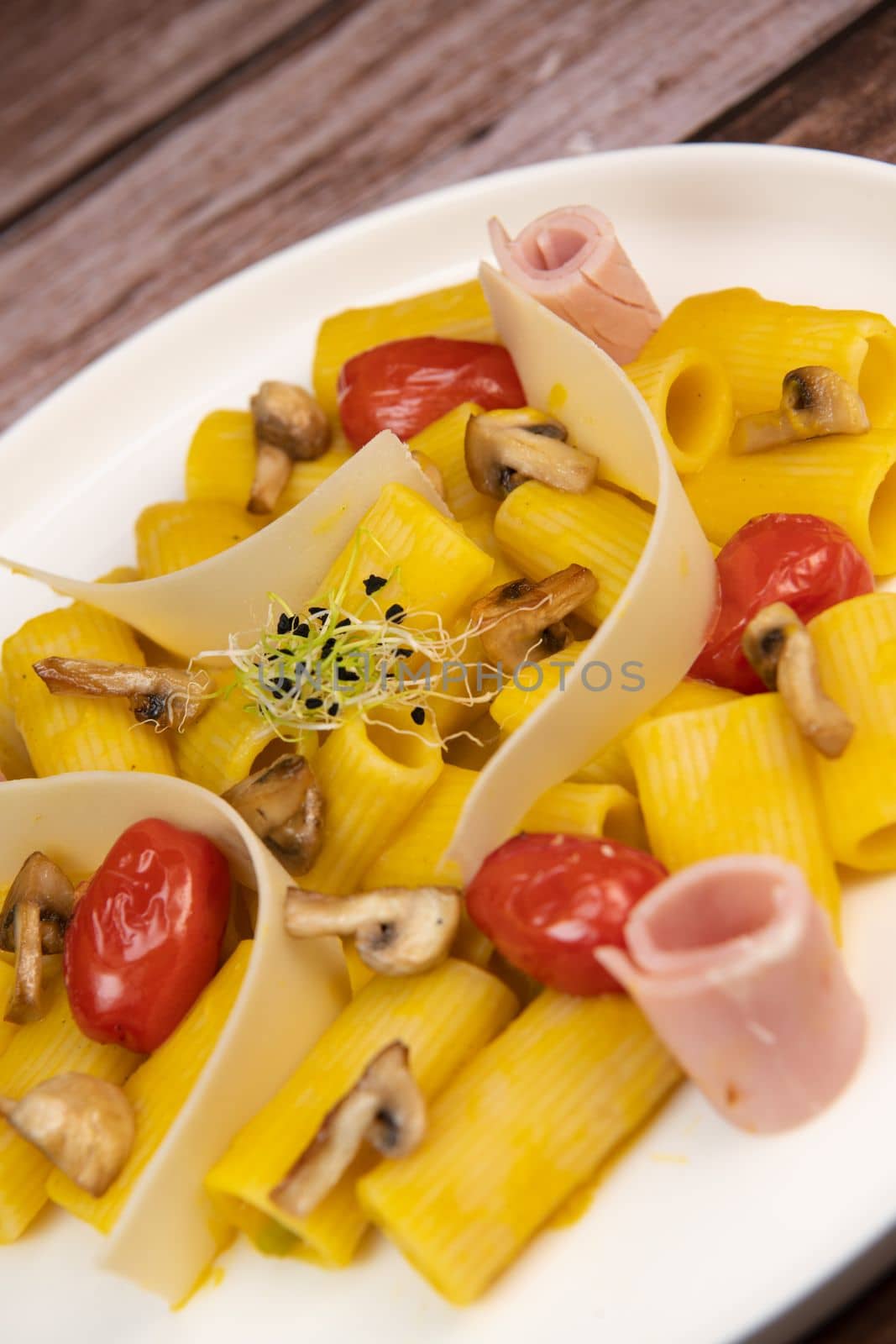 Recipe for Rigatoni Pasta with Chiatsu Squash Cream, Ham, Tomato, Mushrooms and Parmesan. High quality photo