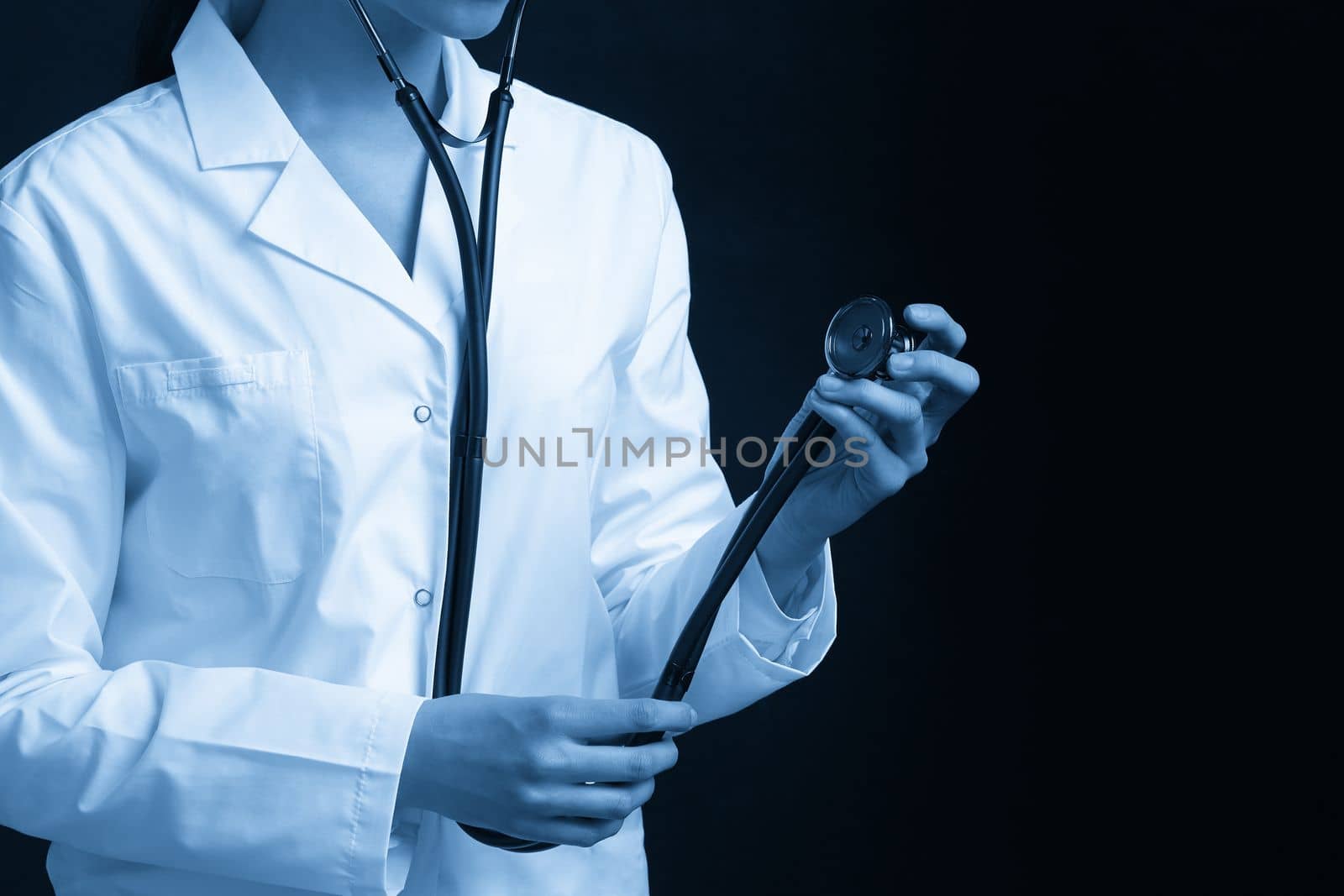 Young female doctor holding stethoscope hanging on her neck