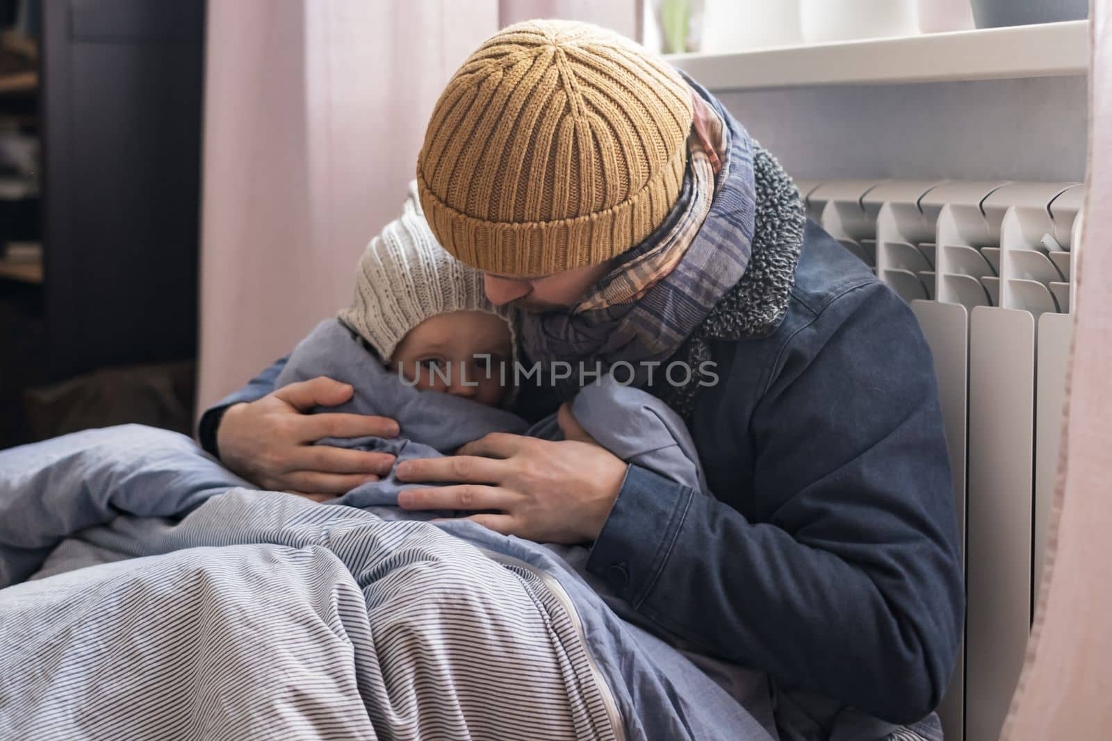 Man wearing warm clothing feeling cold checking central heating battery. Energy crisis in Europe