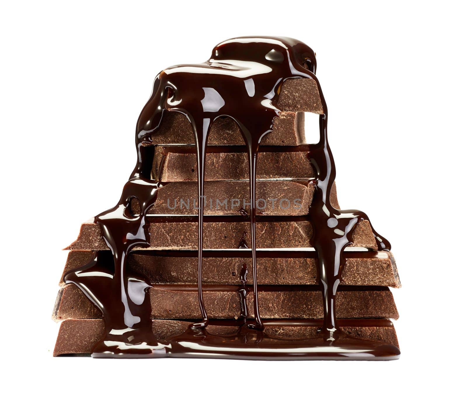 close up of chocolate pieces stack and chocolate syrup on white background