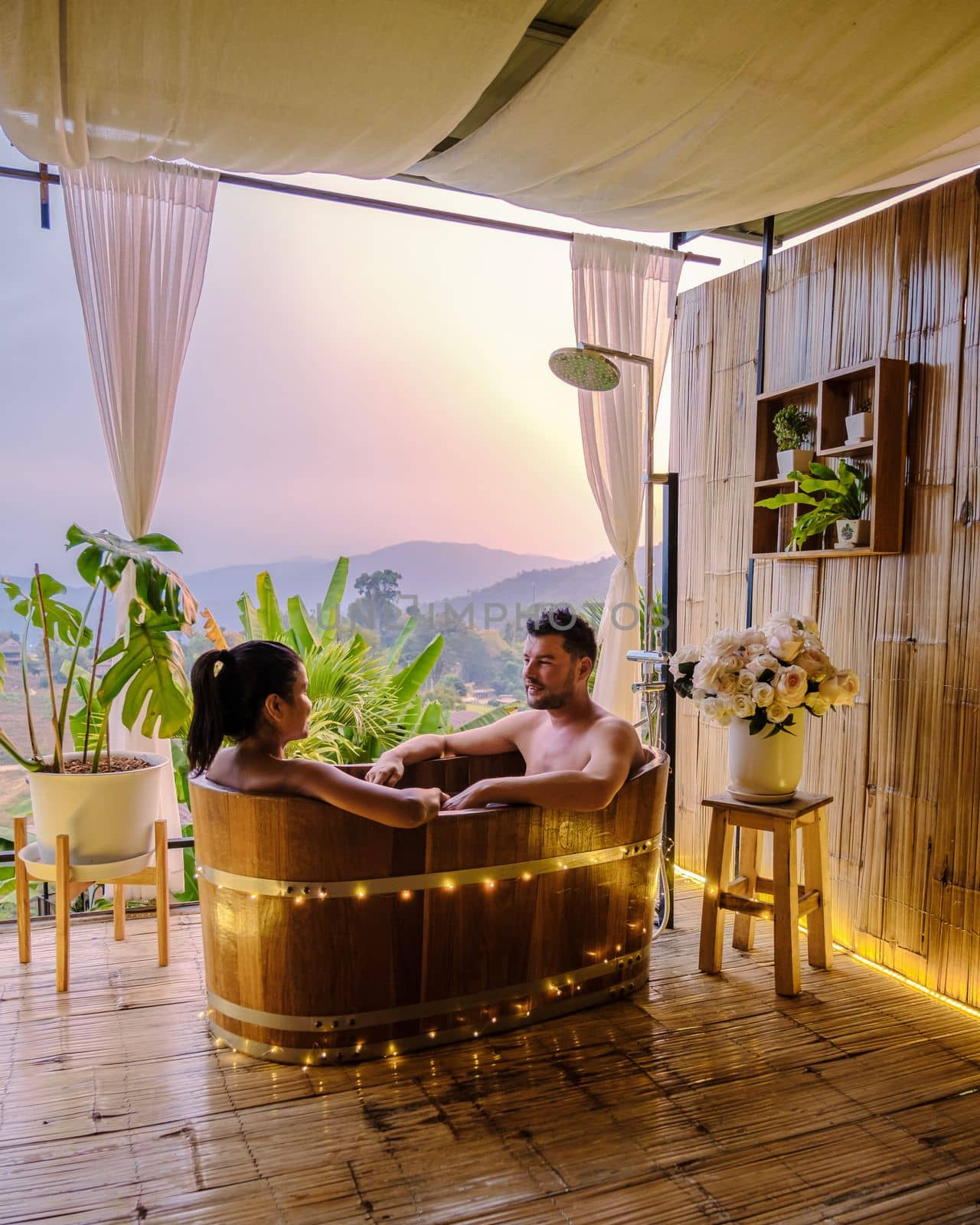 A couple of men and women in a bathtub in the evening during sunset, a couple in a bathtub.