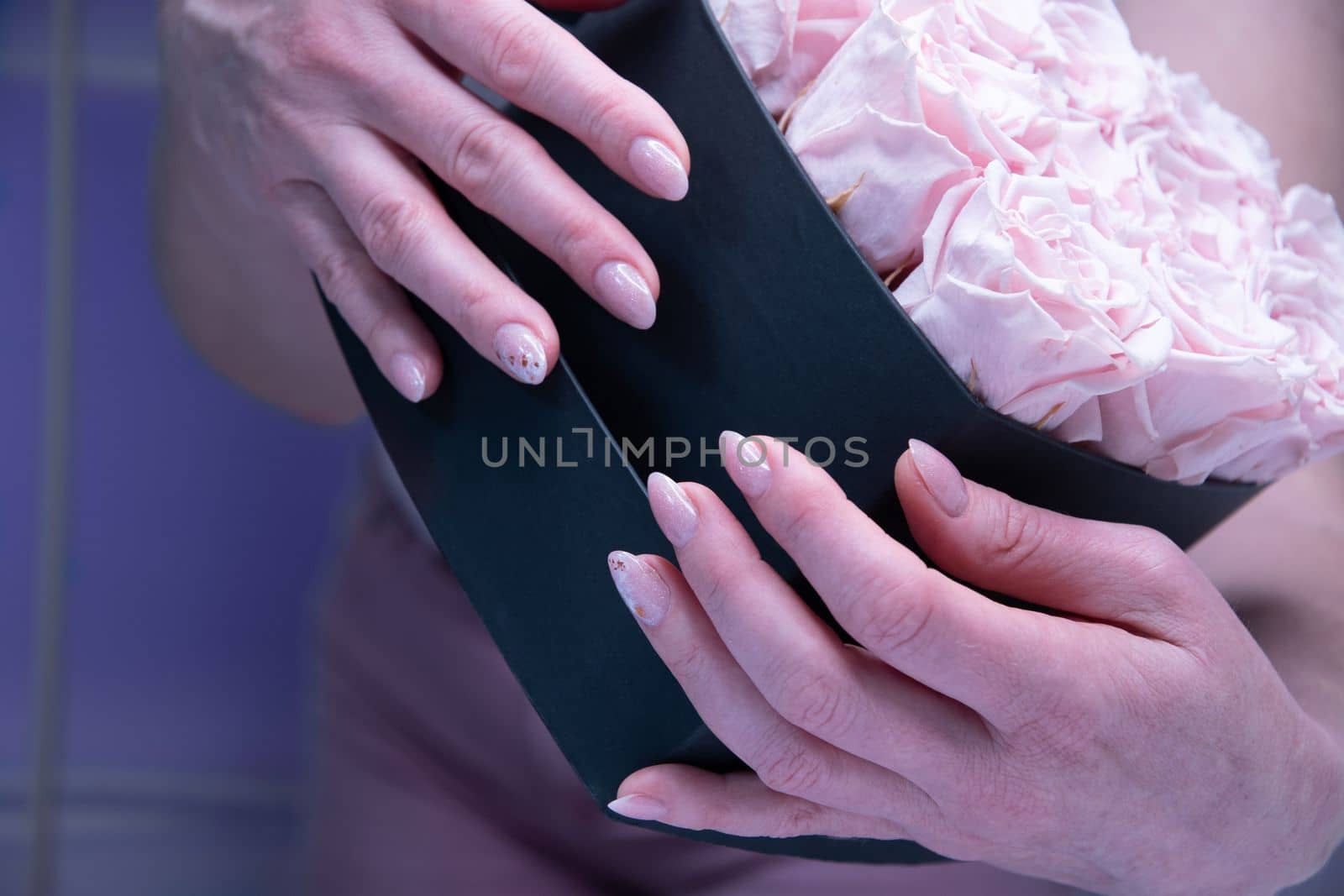 pink wedding manicure for the bride, a girls hand on the black heart shape box. High quality photo
