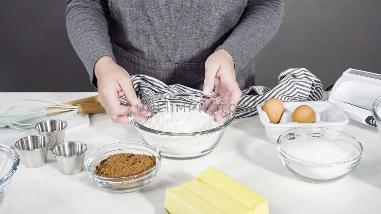 Step by step. Mixing ingredients in a glass mixing bowl to bake chocolate cookies.