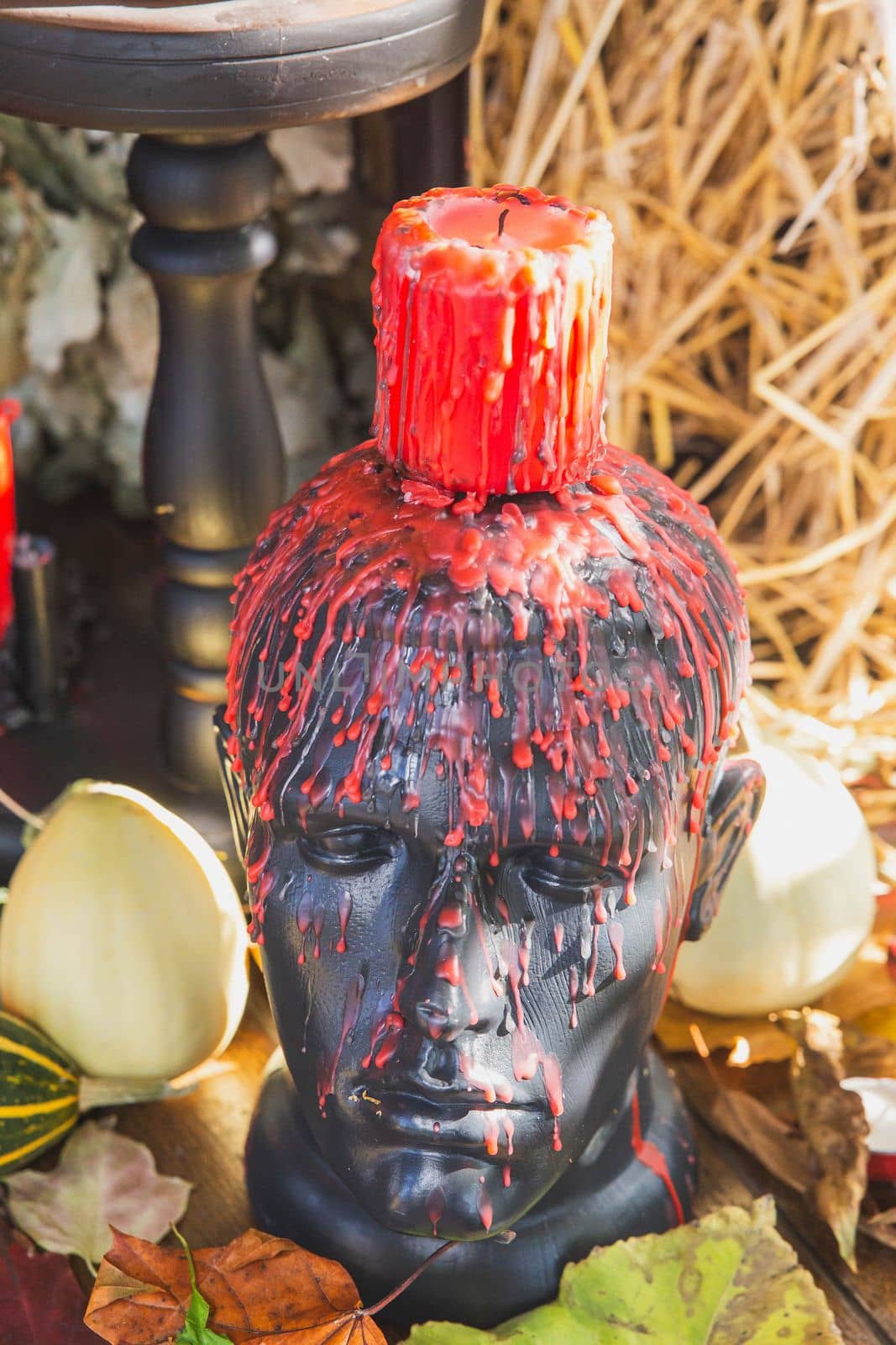 Mannequin head with candle and wax drips for Halloween.