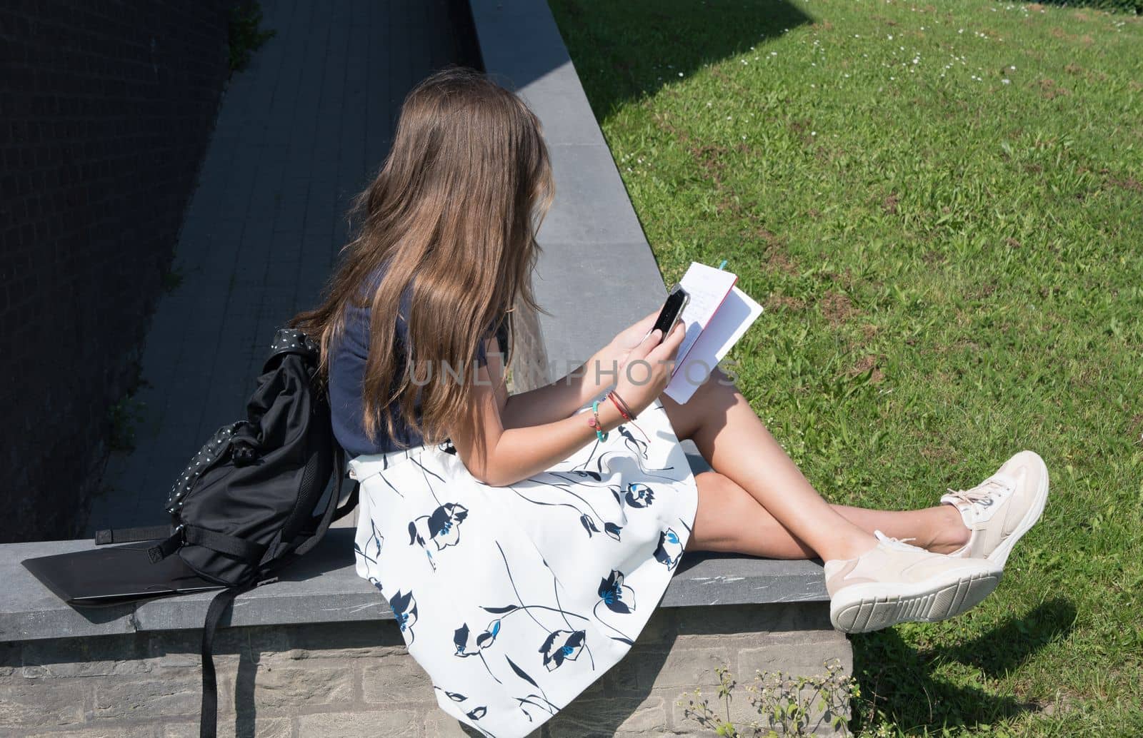 teenage girl student copying text using phone to send to her classmate using mobile phone technology. High quality photo