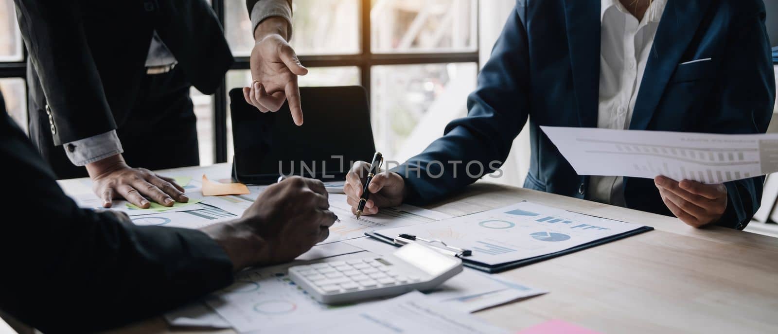 Business People Meeting using laptop computer,calculator,notebook,stock market chart paper for analysis Plans to improve quality next month. Conference Discussion Corporate Concept...