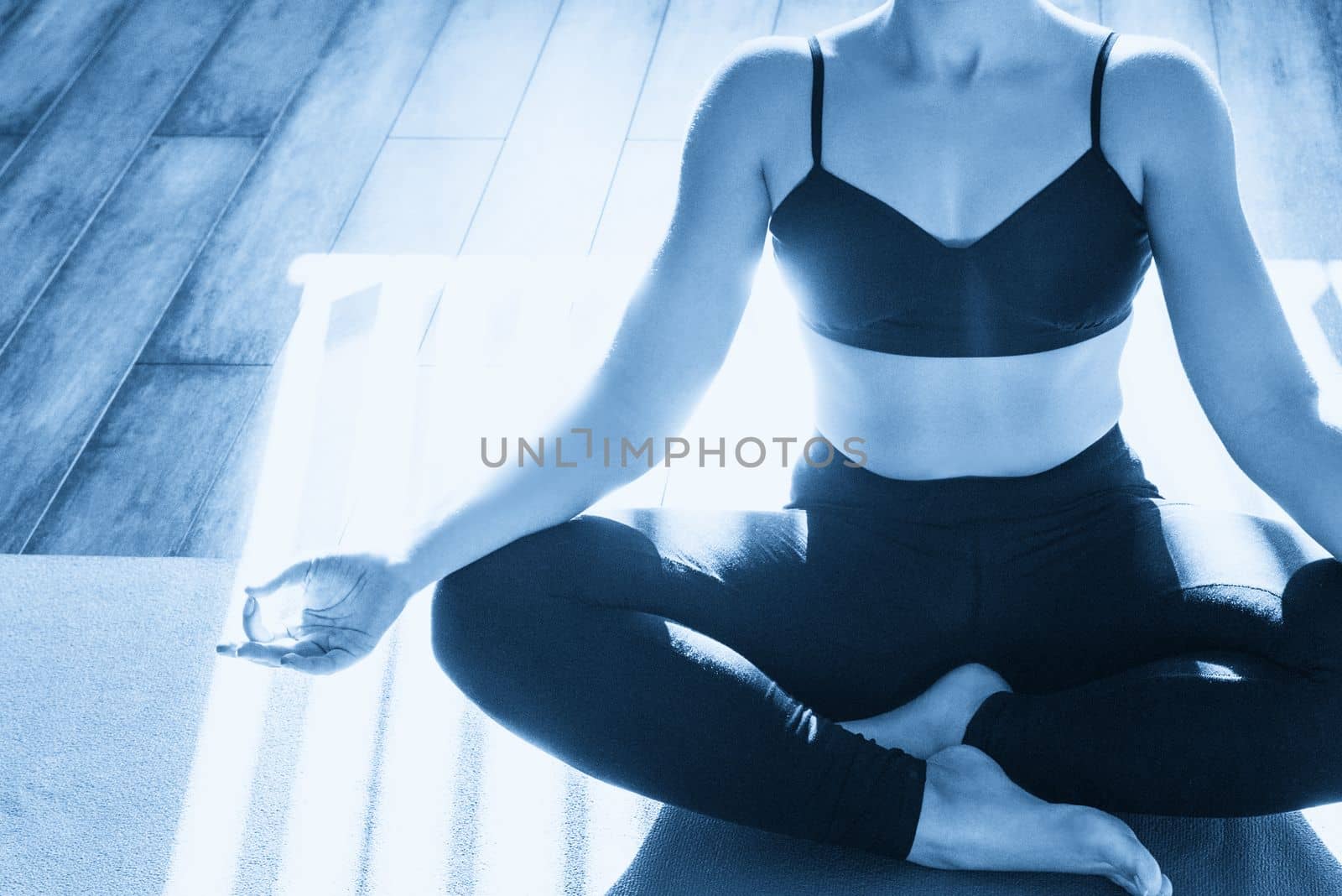 Young woman meditating sitting in lotus position with copy space by Mariakray