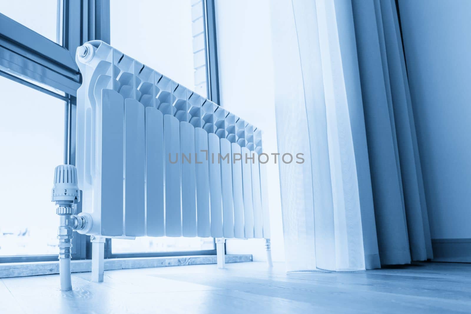 White big radiator near window in modern room, sepia toning by Mariakray