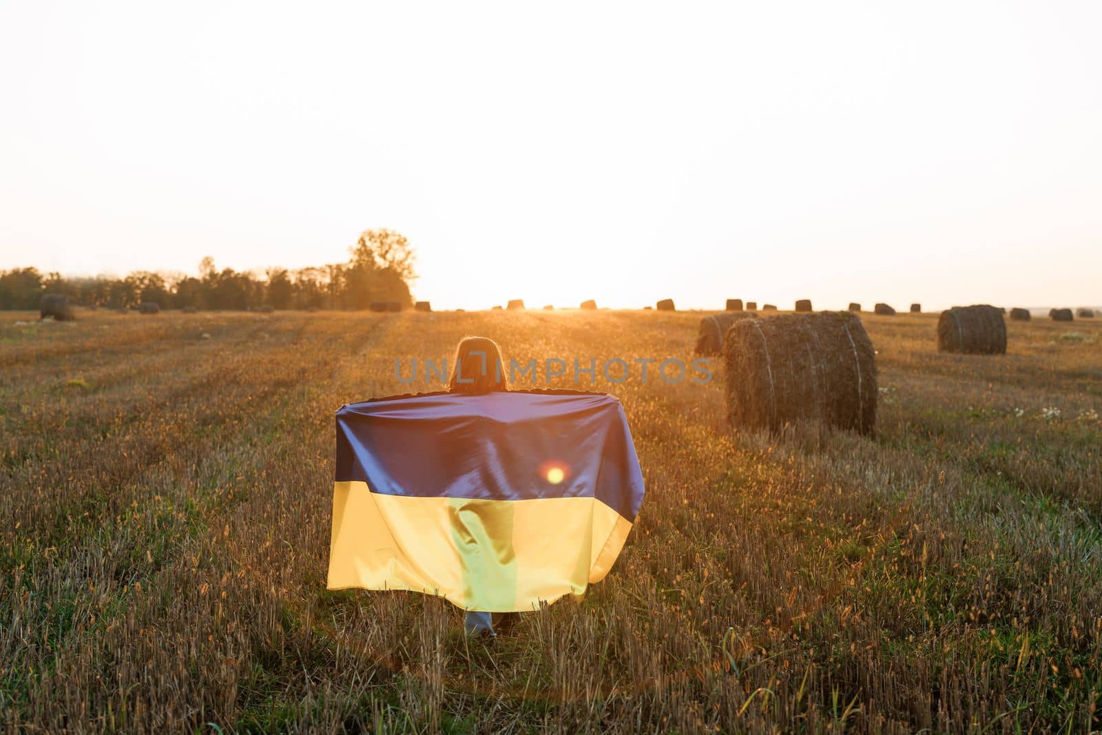 Kid standing outdoors at sunset. International day of democracy concept. Flag Day. Constitution day. Patriotic Girl Flying Ukrainian Flag, Ukraine August 24 banner by uflypro