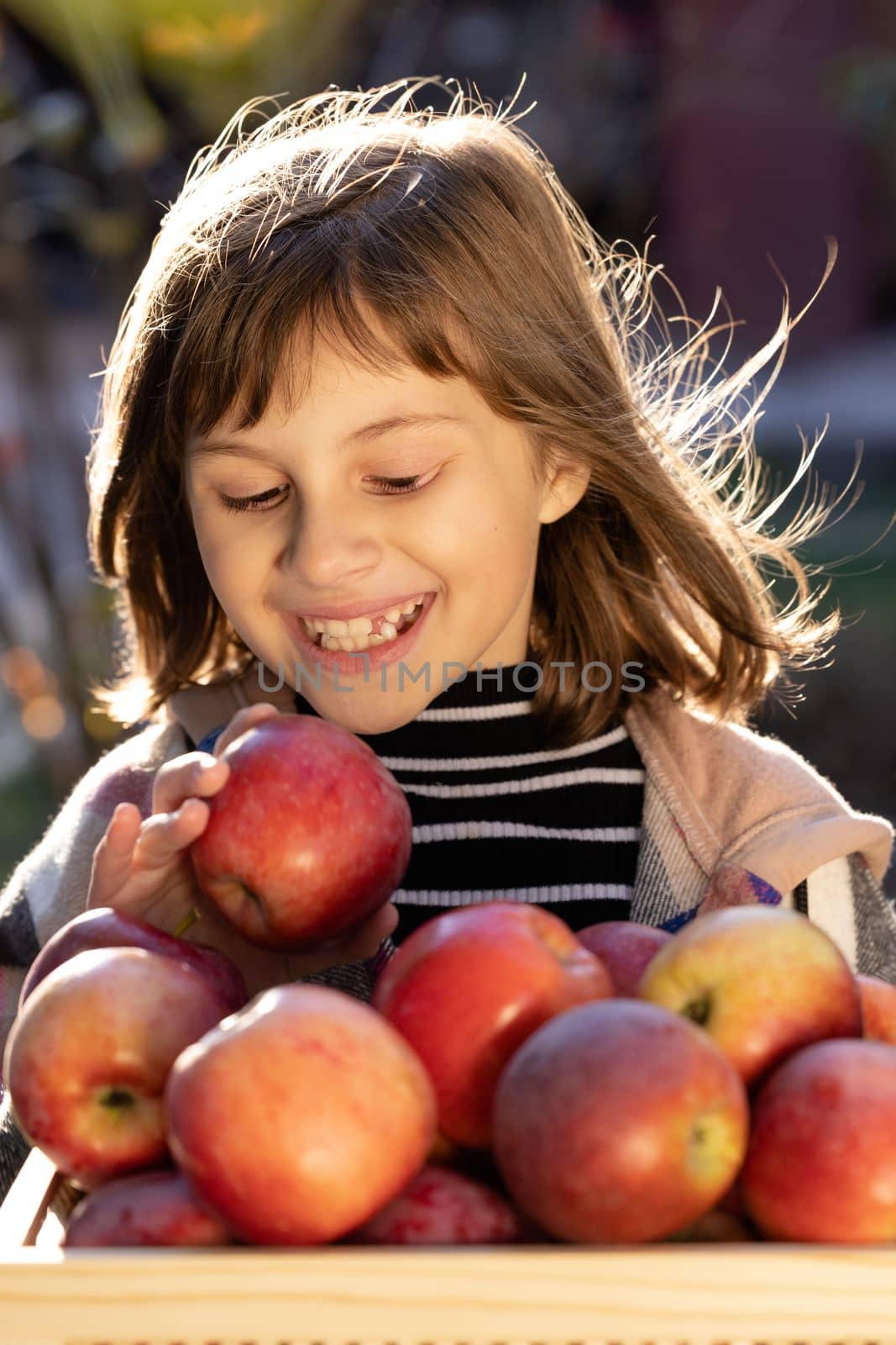 Attractive caucasian girl with apple. Smiling happy child with fresh fruit - emotional portrait close-up. Portrait of healthy girl eating big red apple. by uflypro
