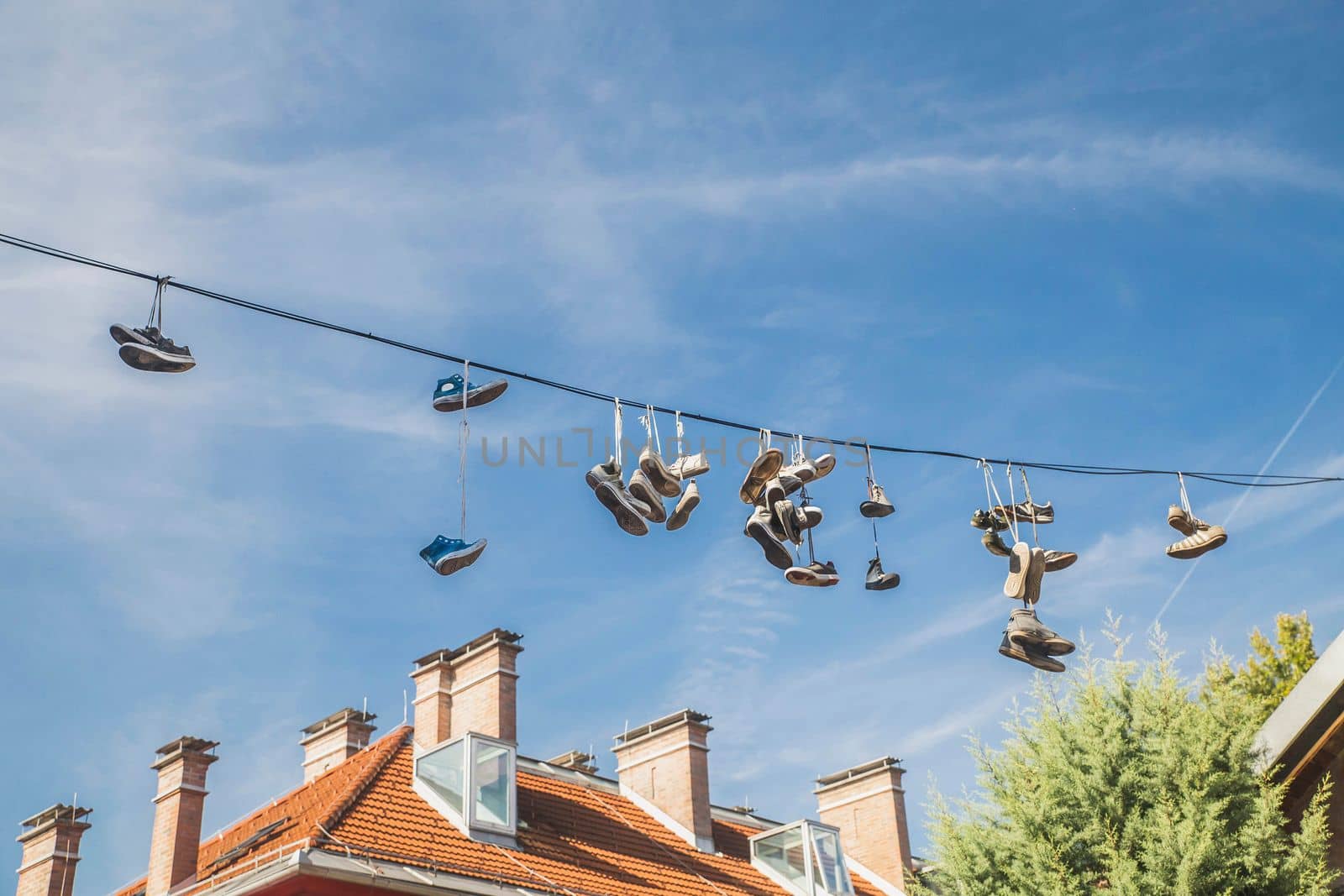 Old worn-out shoes hang from wires in slovenia.