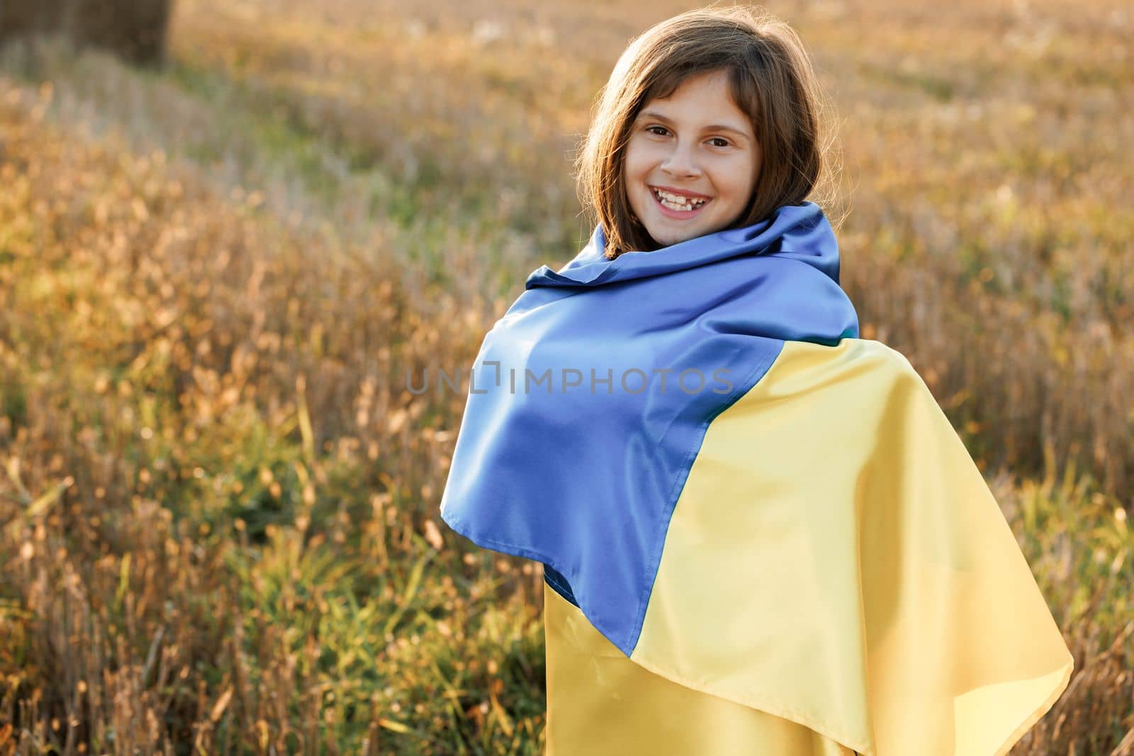 Portrait of little girl in traditional embroidery with flag of Ukraine. Woman holding a yellow and blue flag of Ukraine in outdoors. Independence Day. Flag Day. Constitution day by uflypro