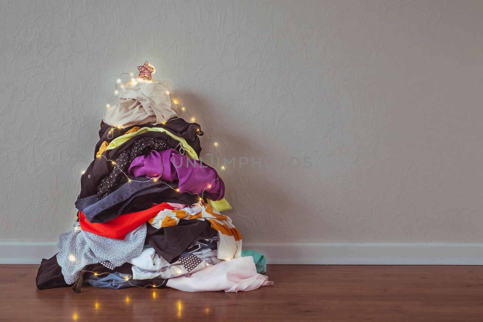 A pile of clothes in the shape of a Christmas tree.