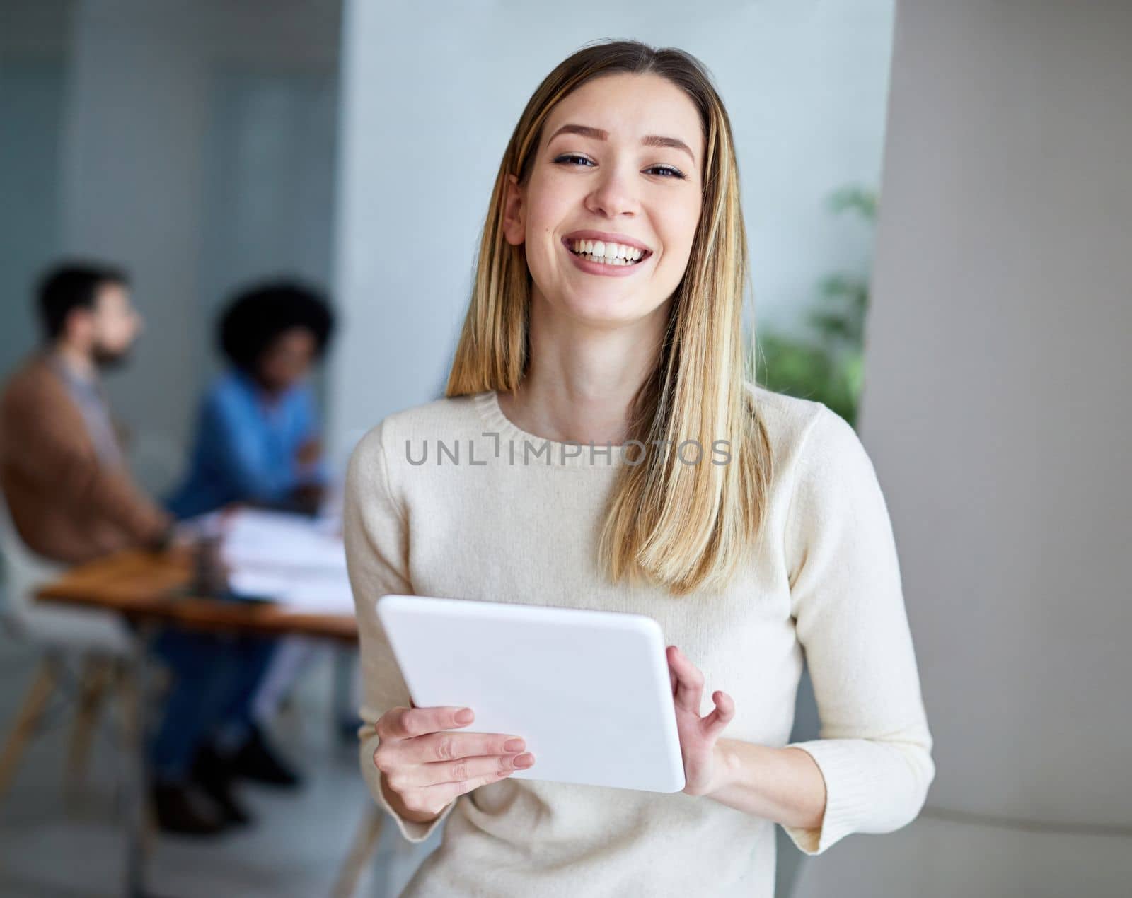 portrait of a smiling young businesswoman holding a tablet in the office