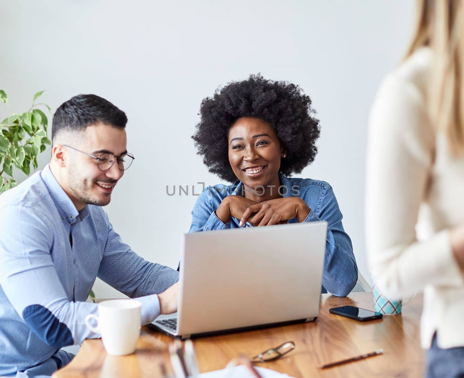 Portrait of young african american businesswoman in the office or in school education with friends laughing and using laptop