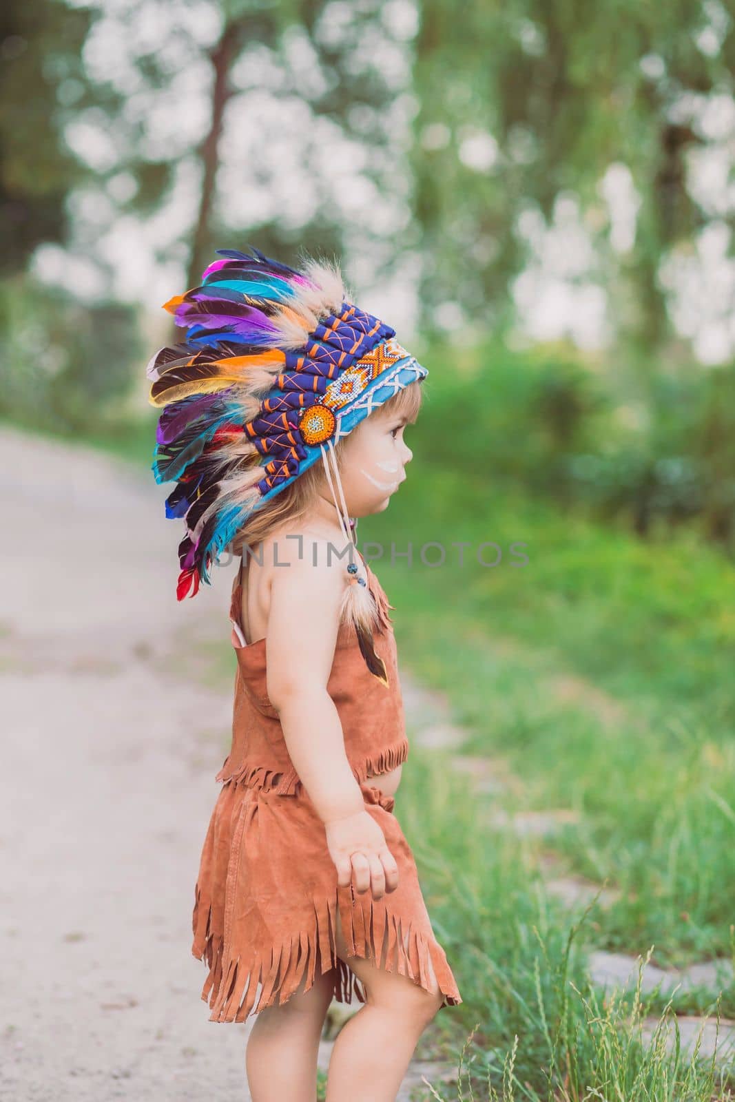 Cute baby dressed in traditional Native Americanс costume.