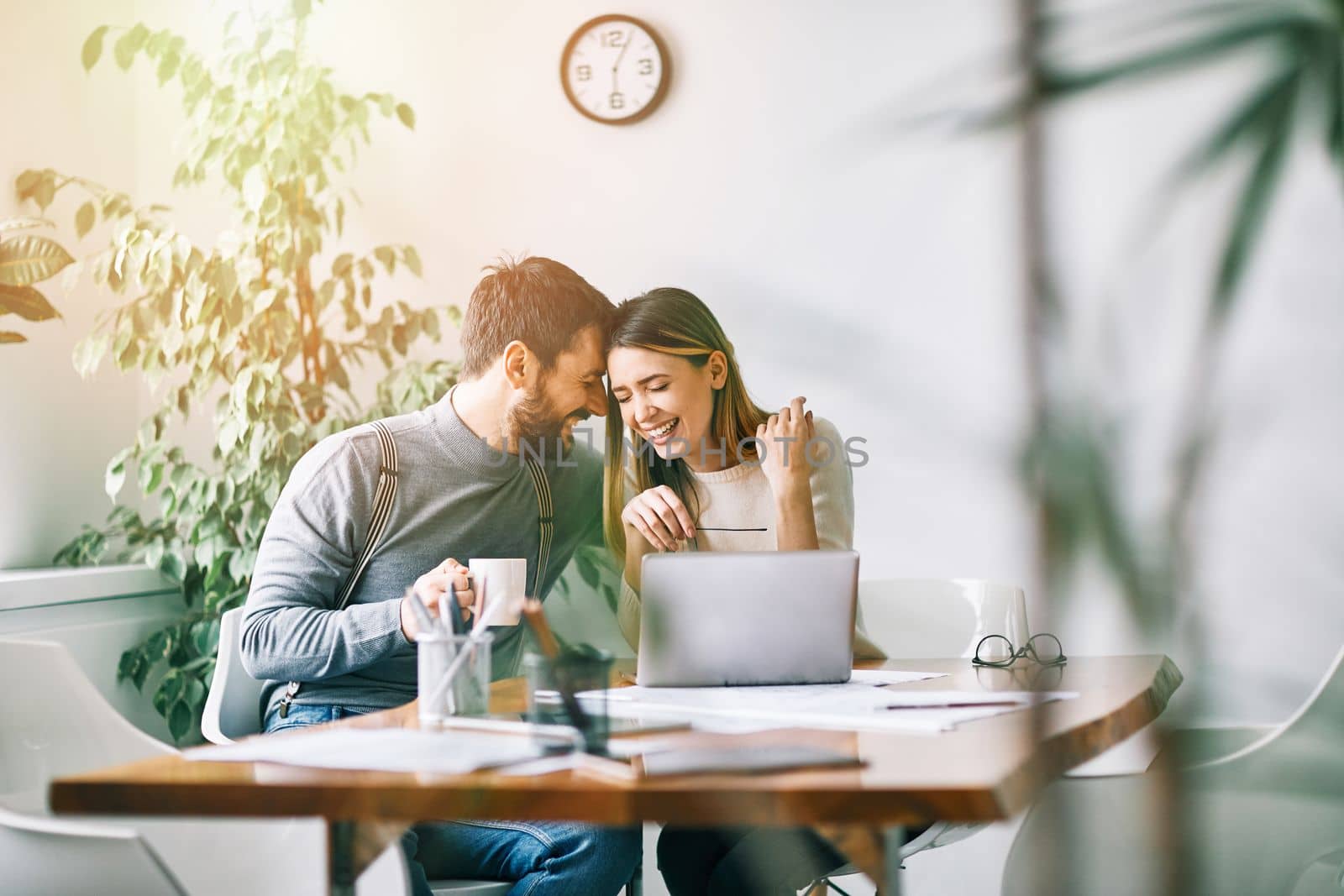 Smiling couple working at home or in teh office with laptop