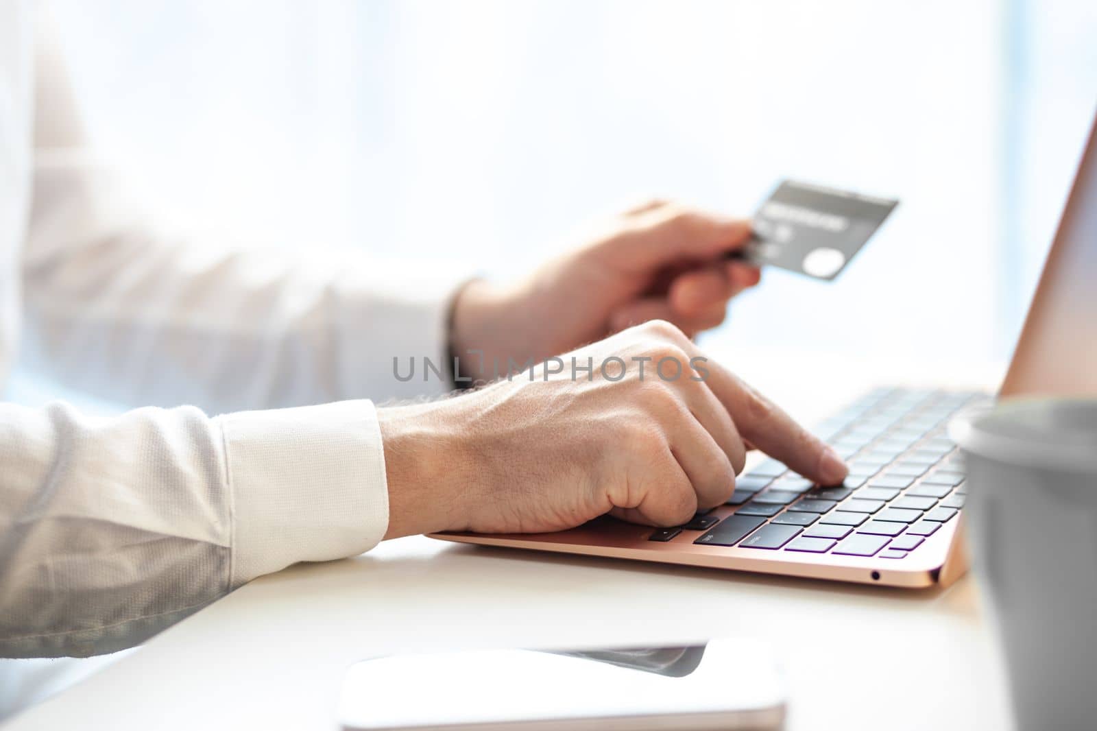 Purchases via the Internet and payment for services buy credit card. Hands type text and enter data on the laptop keyboard. An office worker checks his email while sitting at his desk